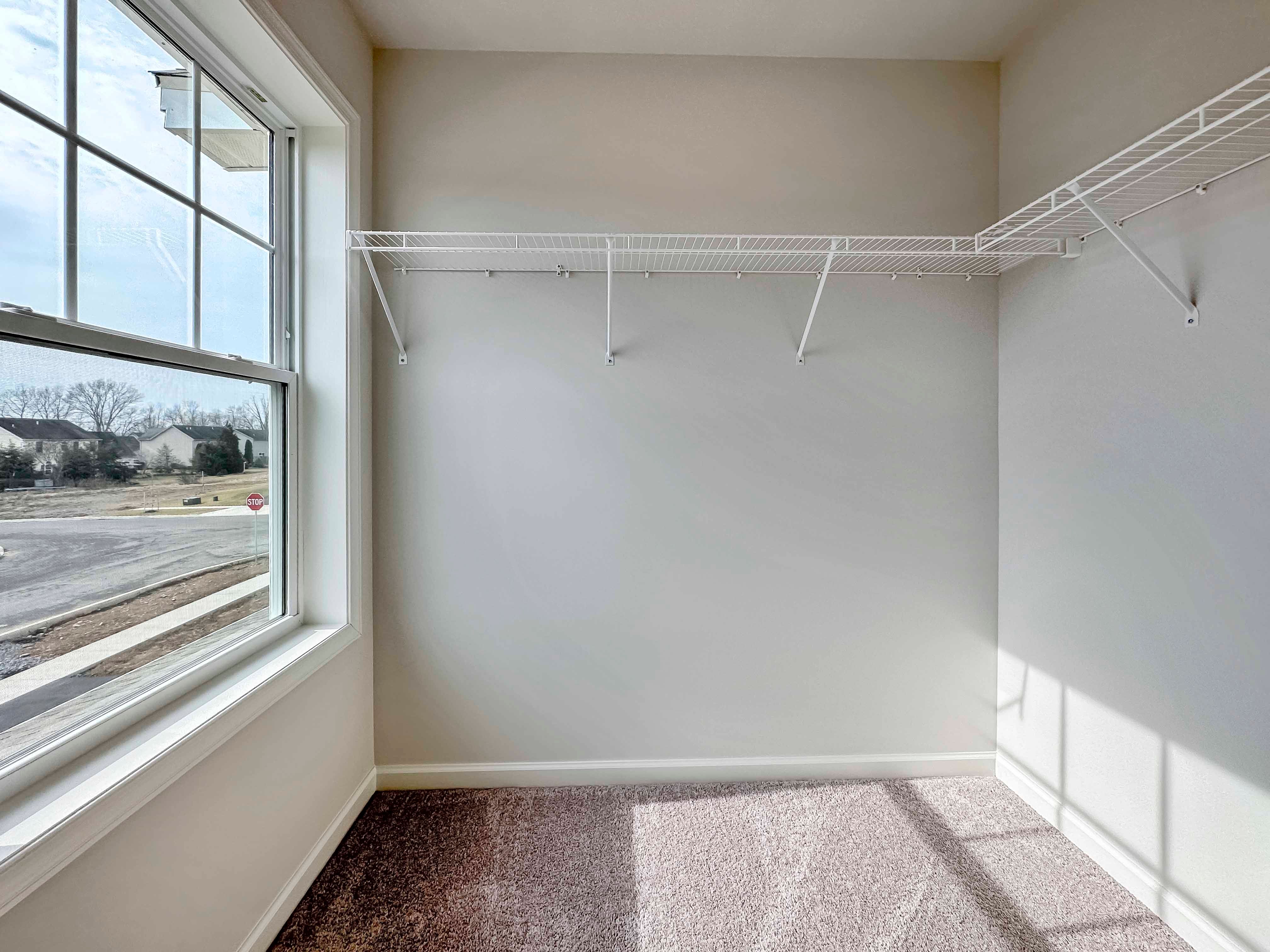 Closet with window on front wall and wire shelving