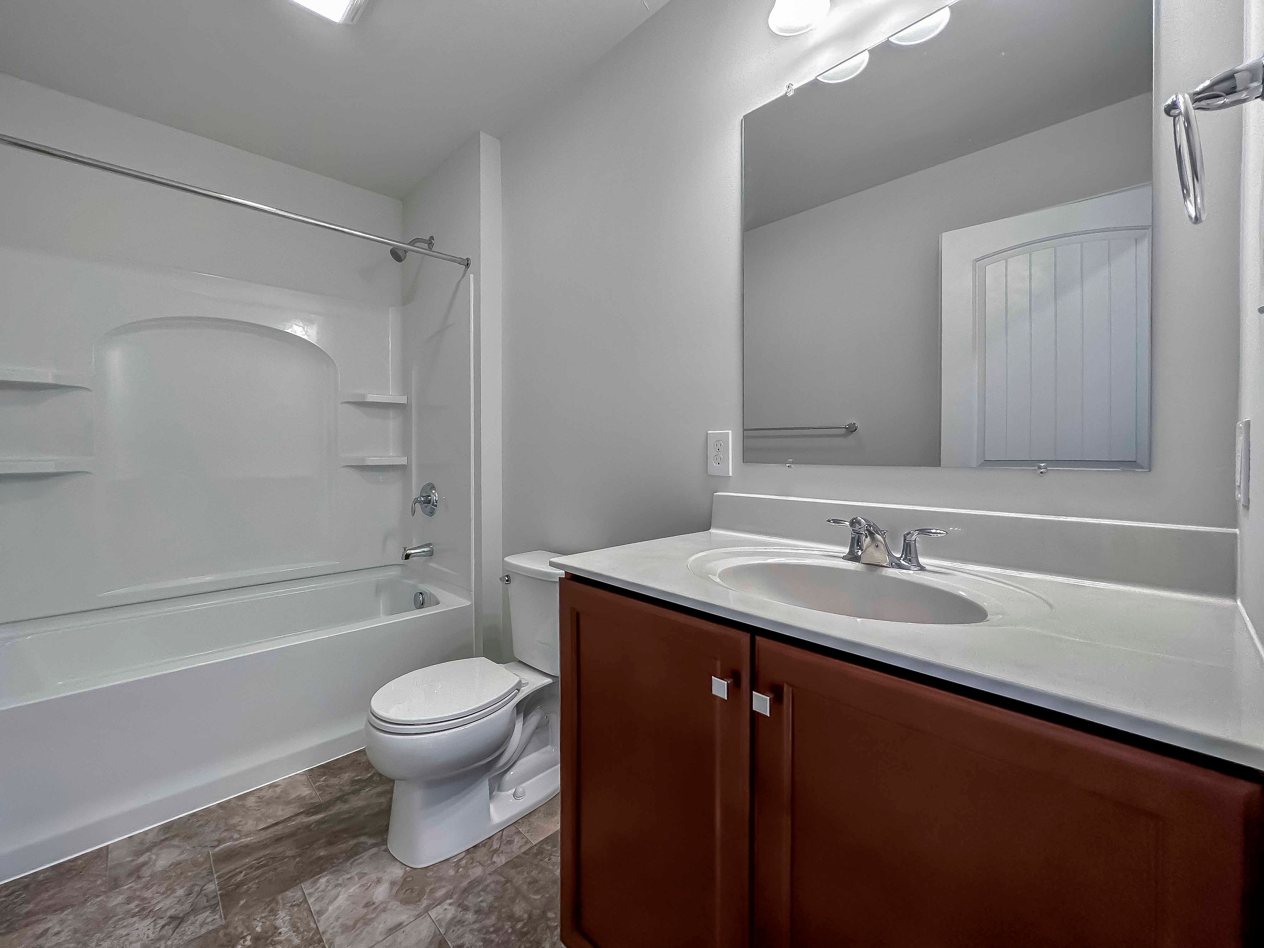 Bathroom with single vanity, toilet and tub shower combination