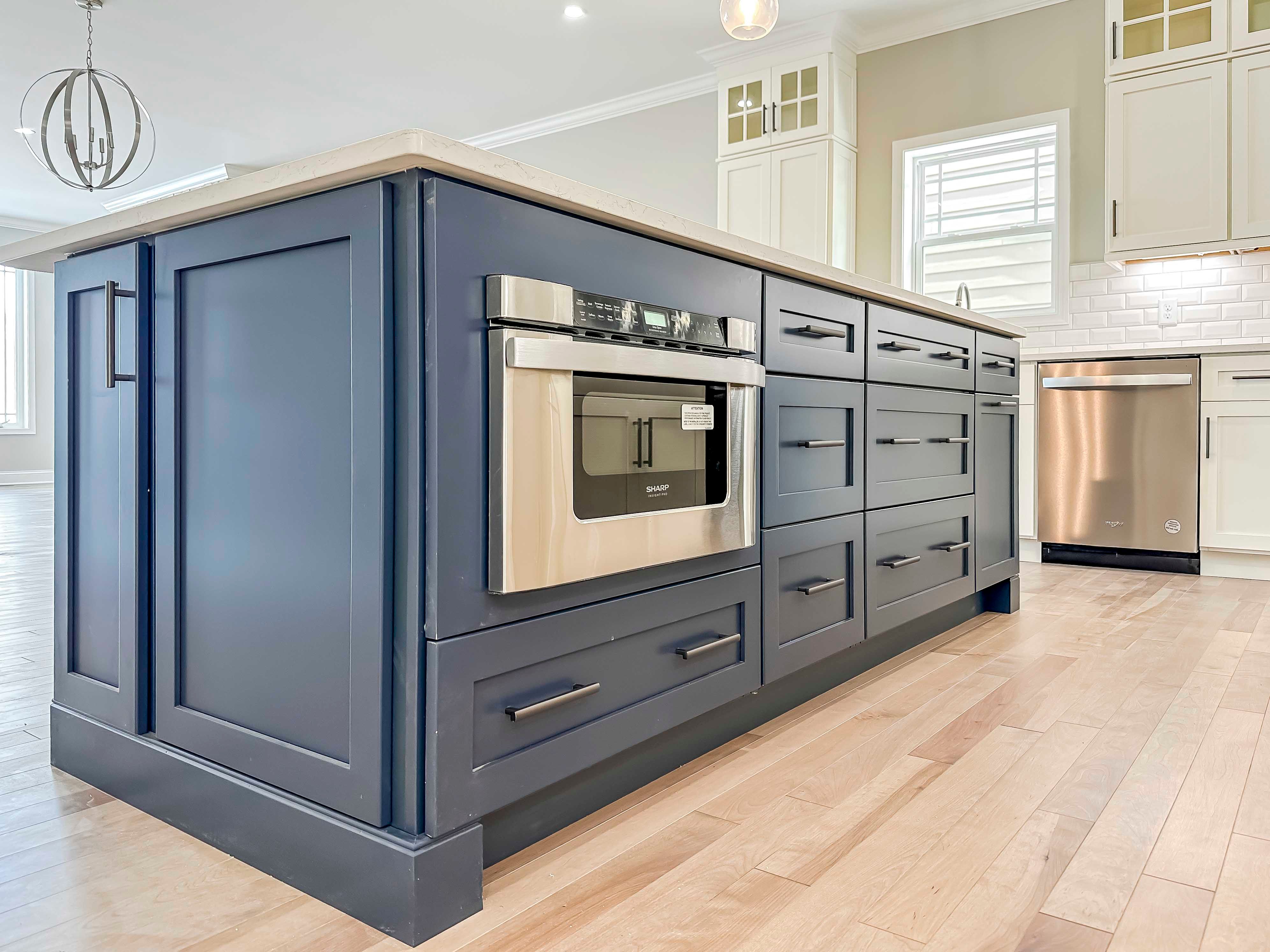 Center island with blue cabinets and built in microwave