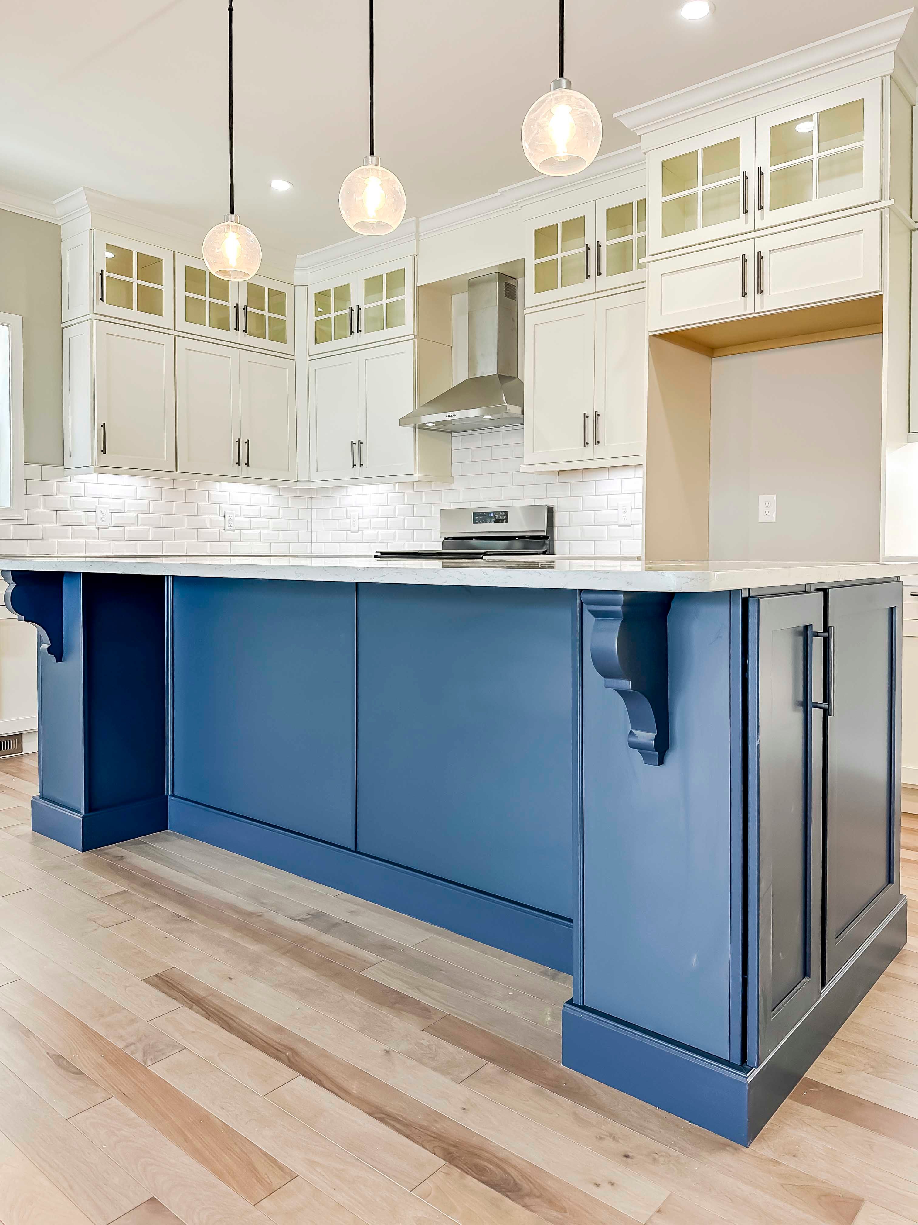 Center island with blue cabinets and overhang