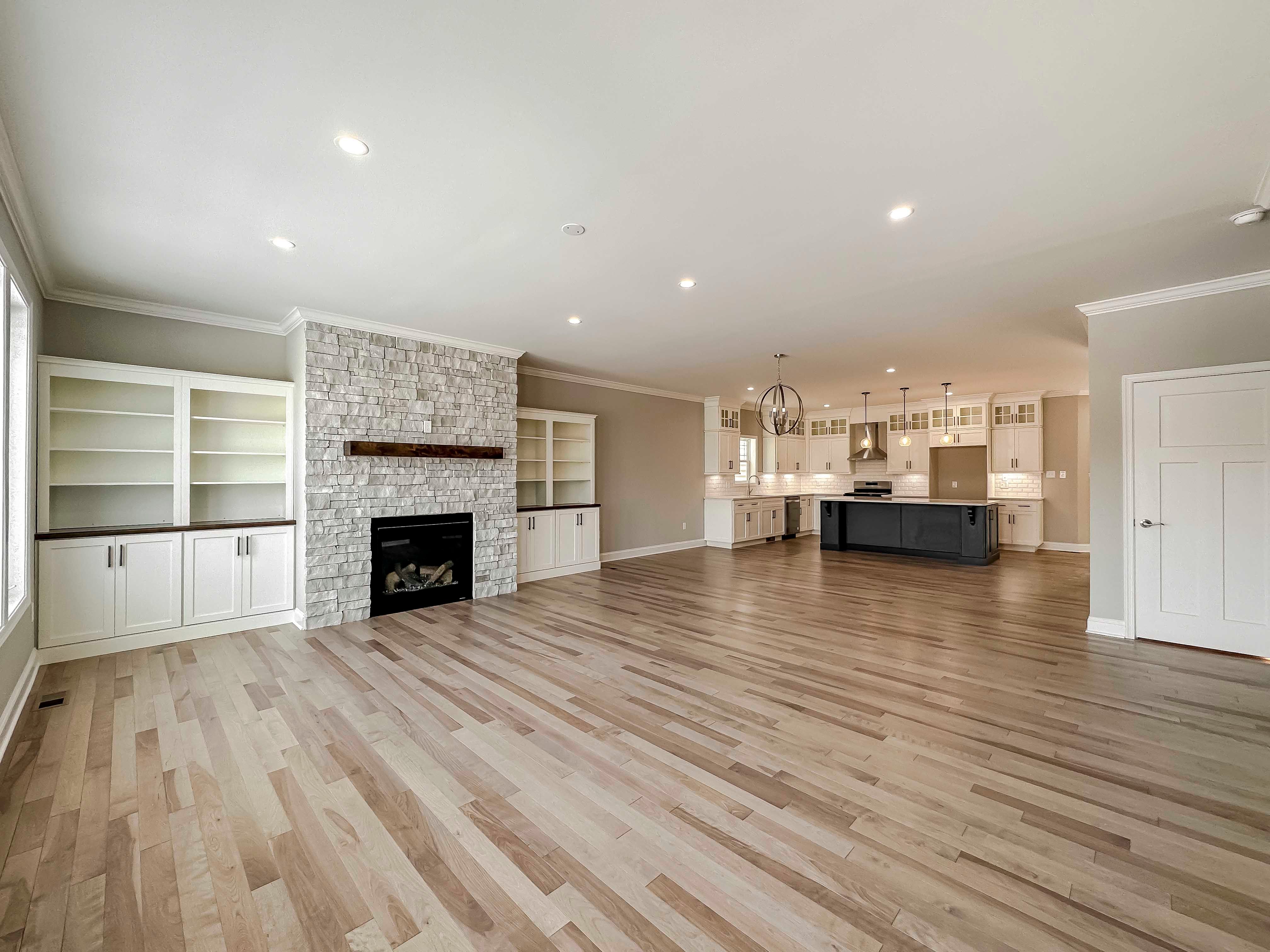 Great room with stone fireplace, hardwood flooring - facing kitchen area