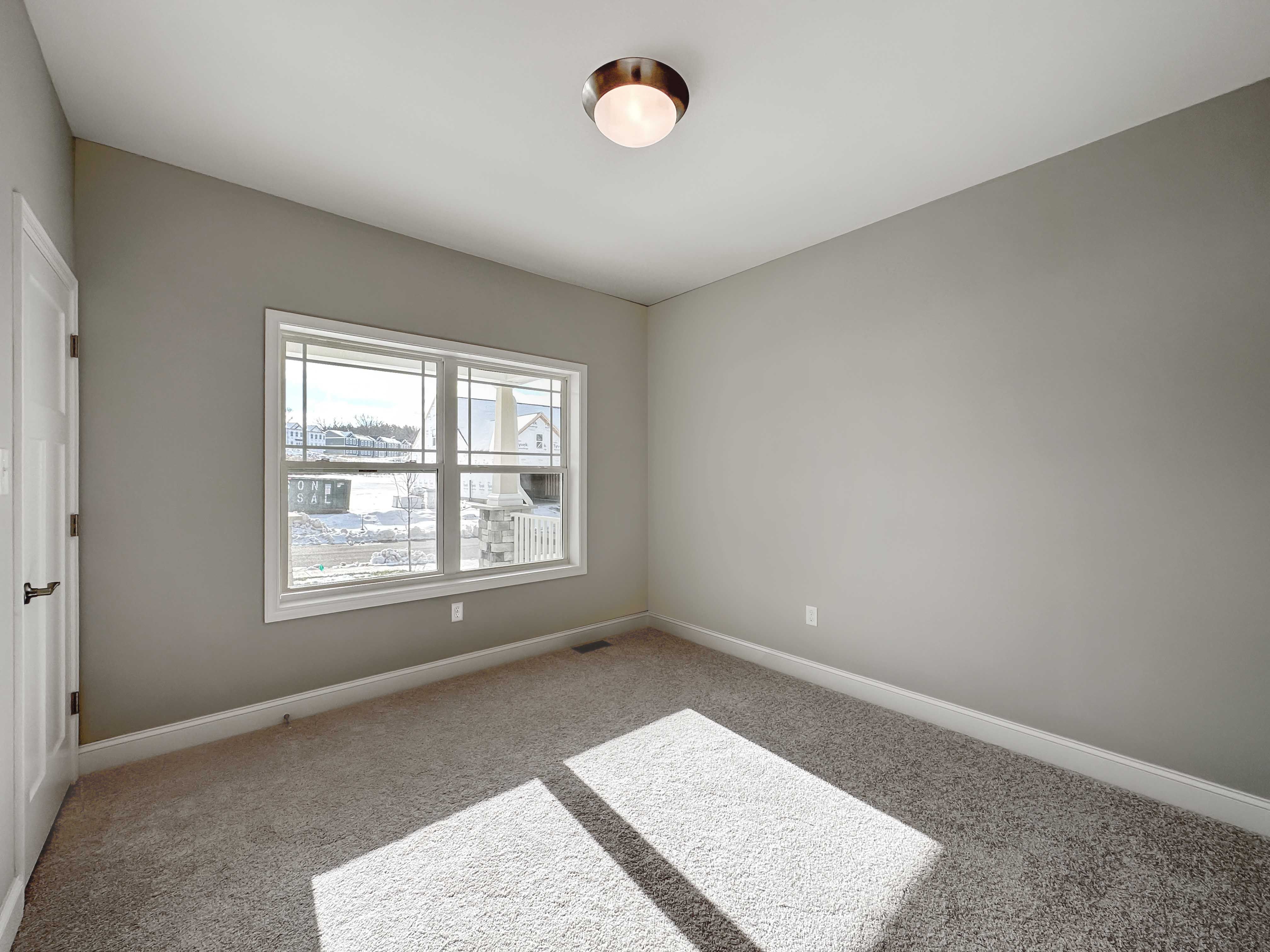 Bedroom with two windows on front wall and carpet flooring