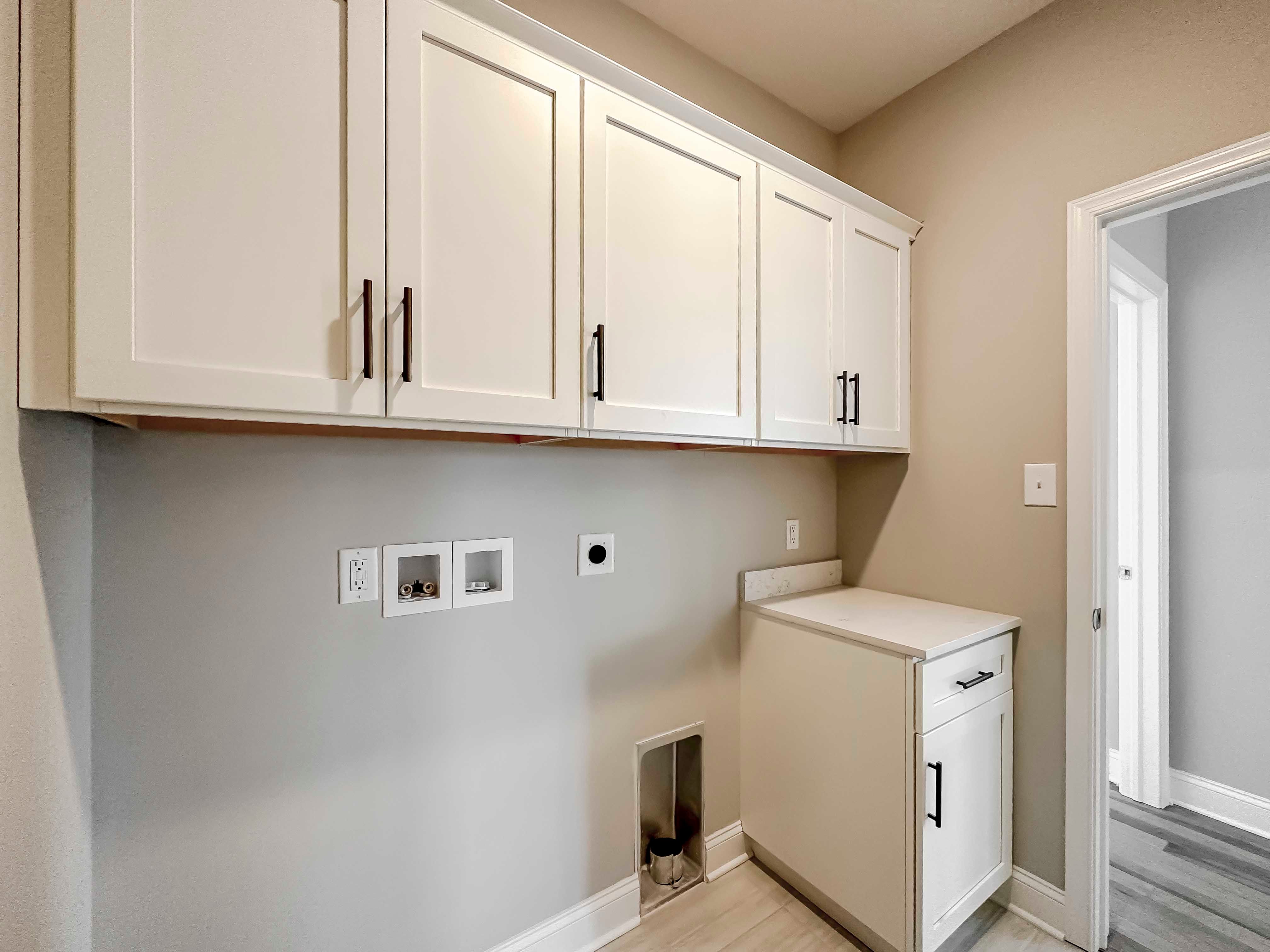 Laundry room with white cabinets