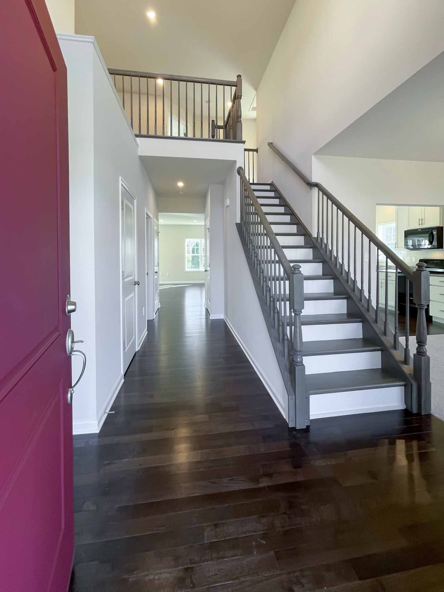 Foyer entry with hardwood flooring and oak stairs with white treads