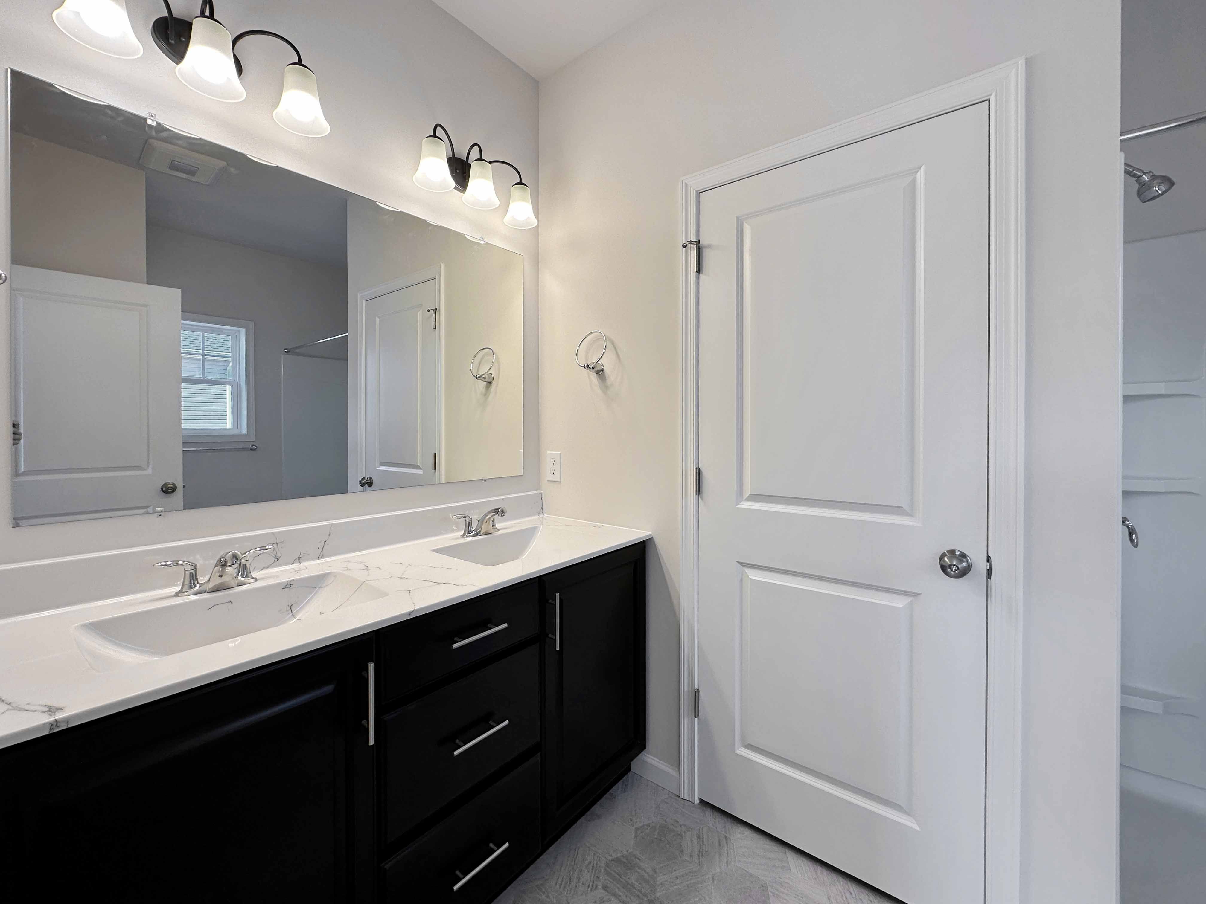 Bathroom with dual vanities and large mirror