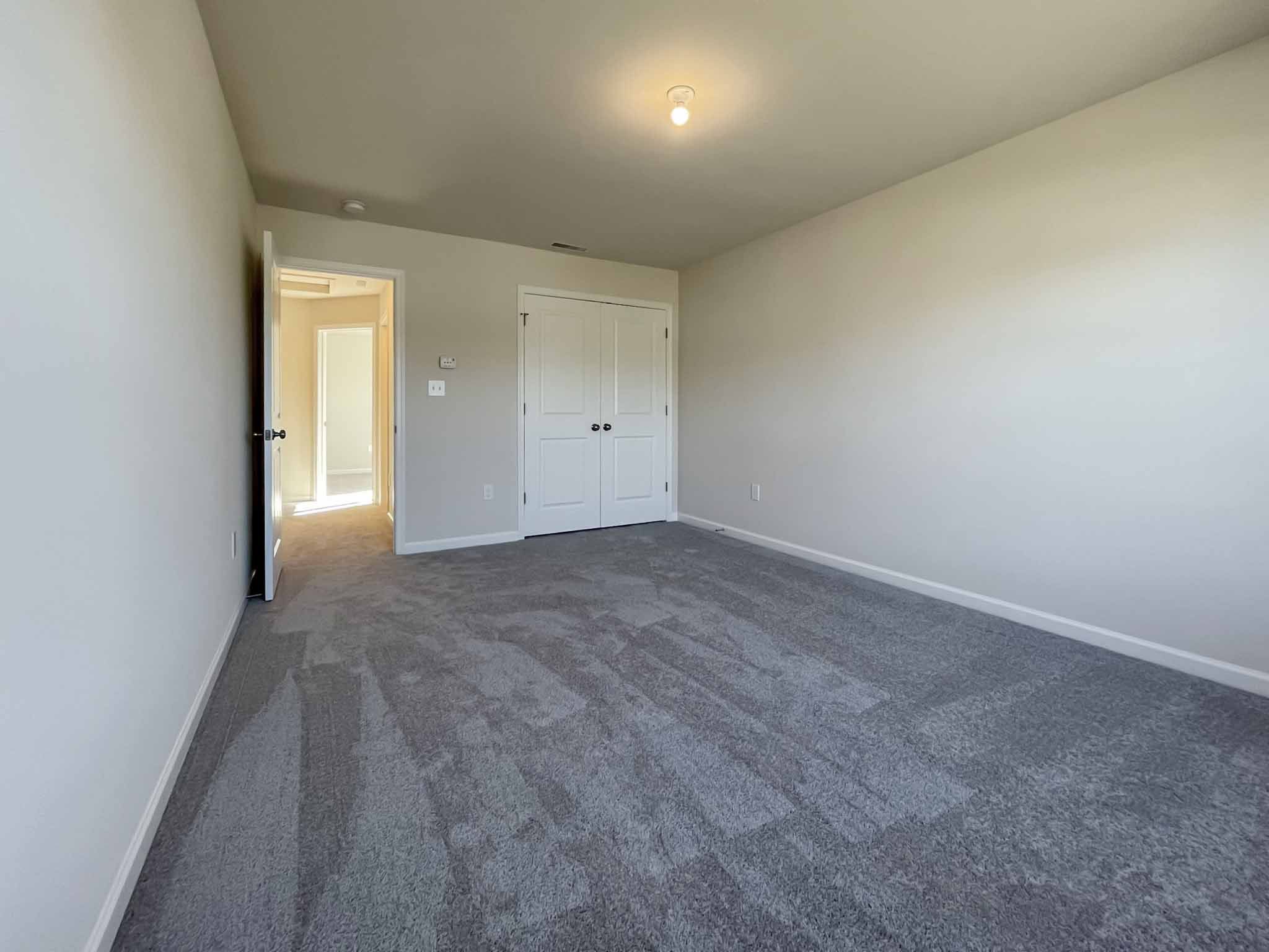 Bedroom with carpet flooring - doorway to hall