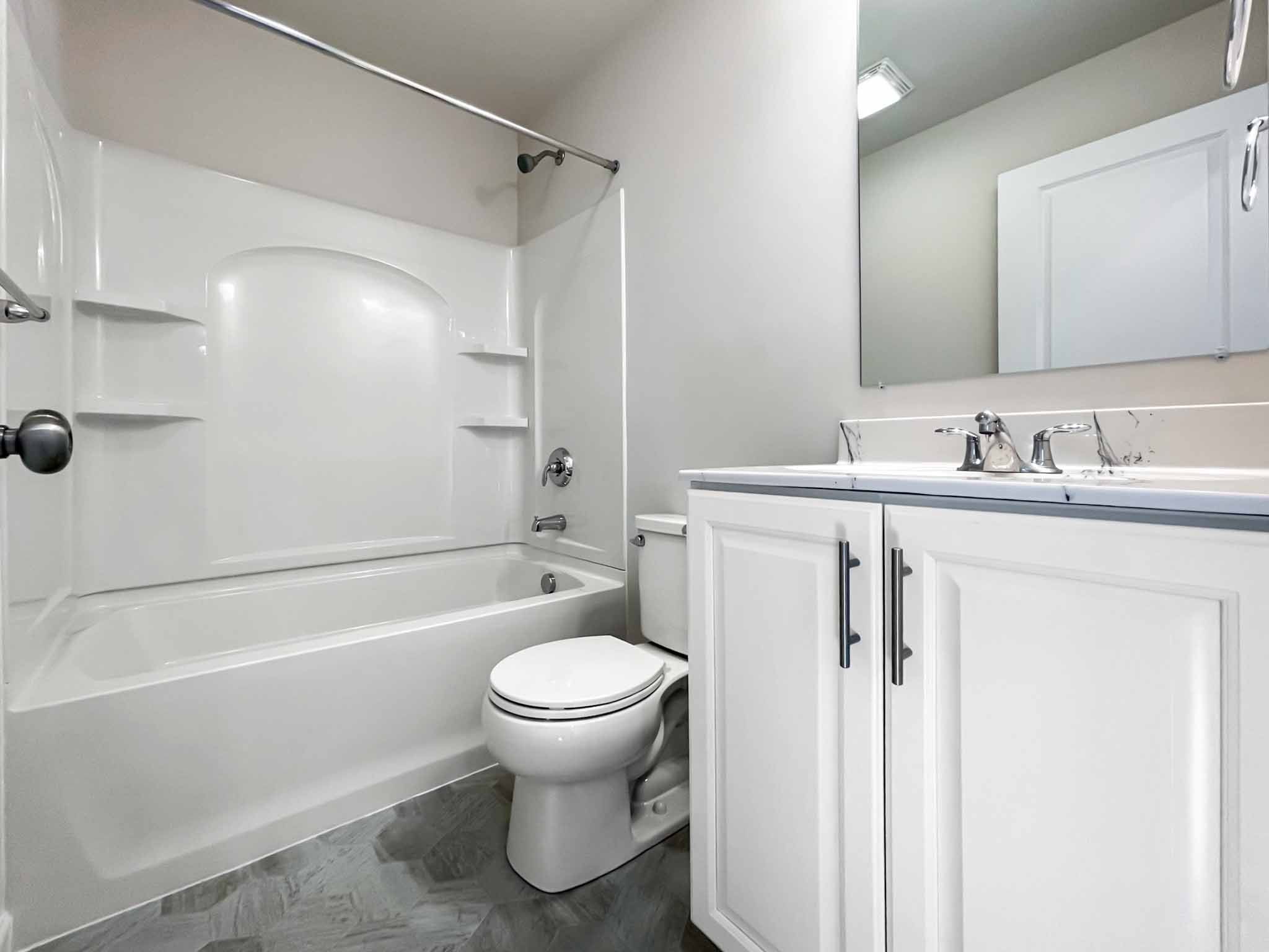 Bathroom with white cabinetry and tub shower combination