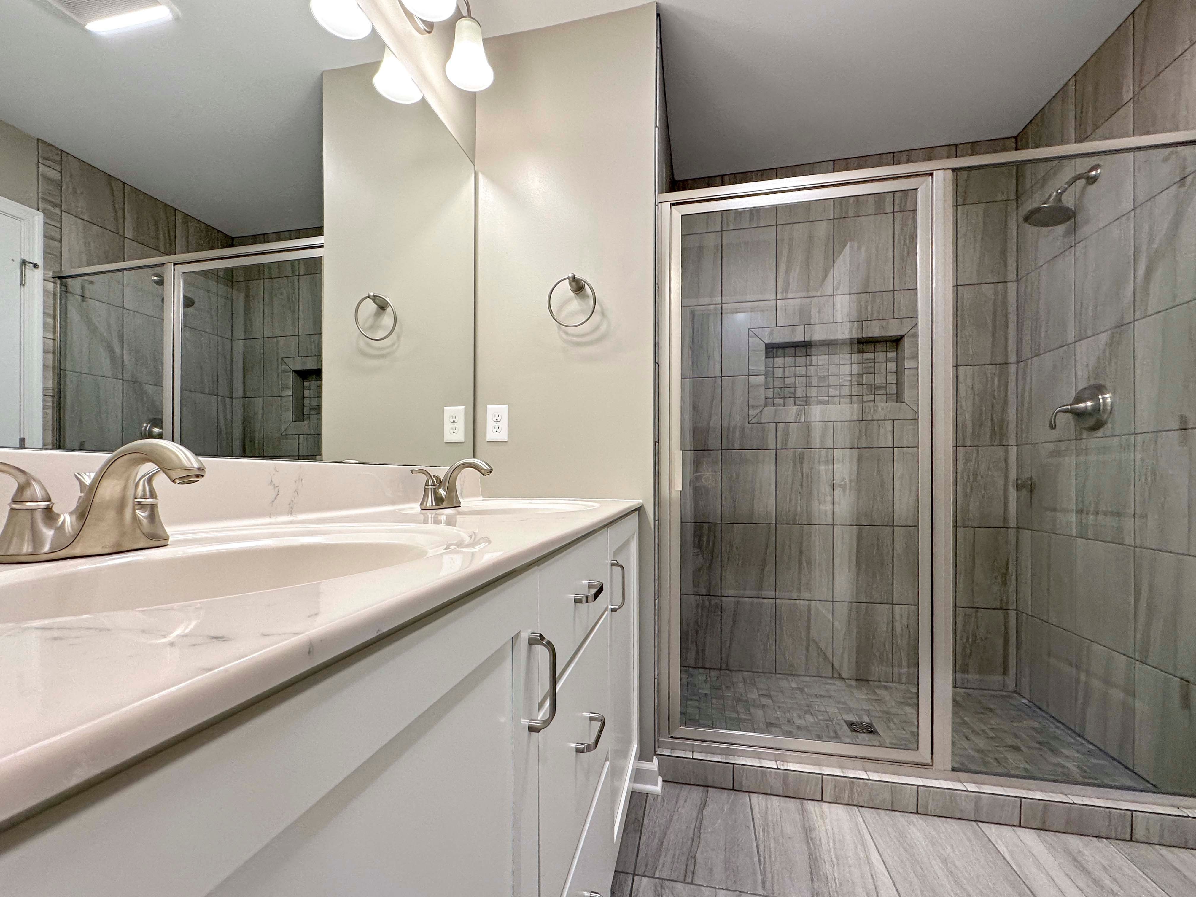 Bathroom with ceramic tile showerand dual vanity