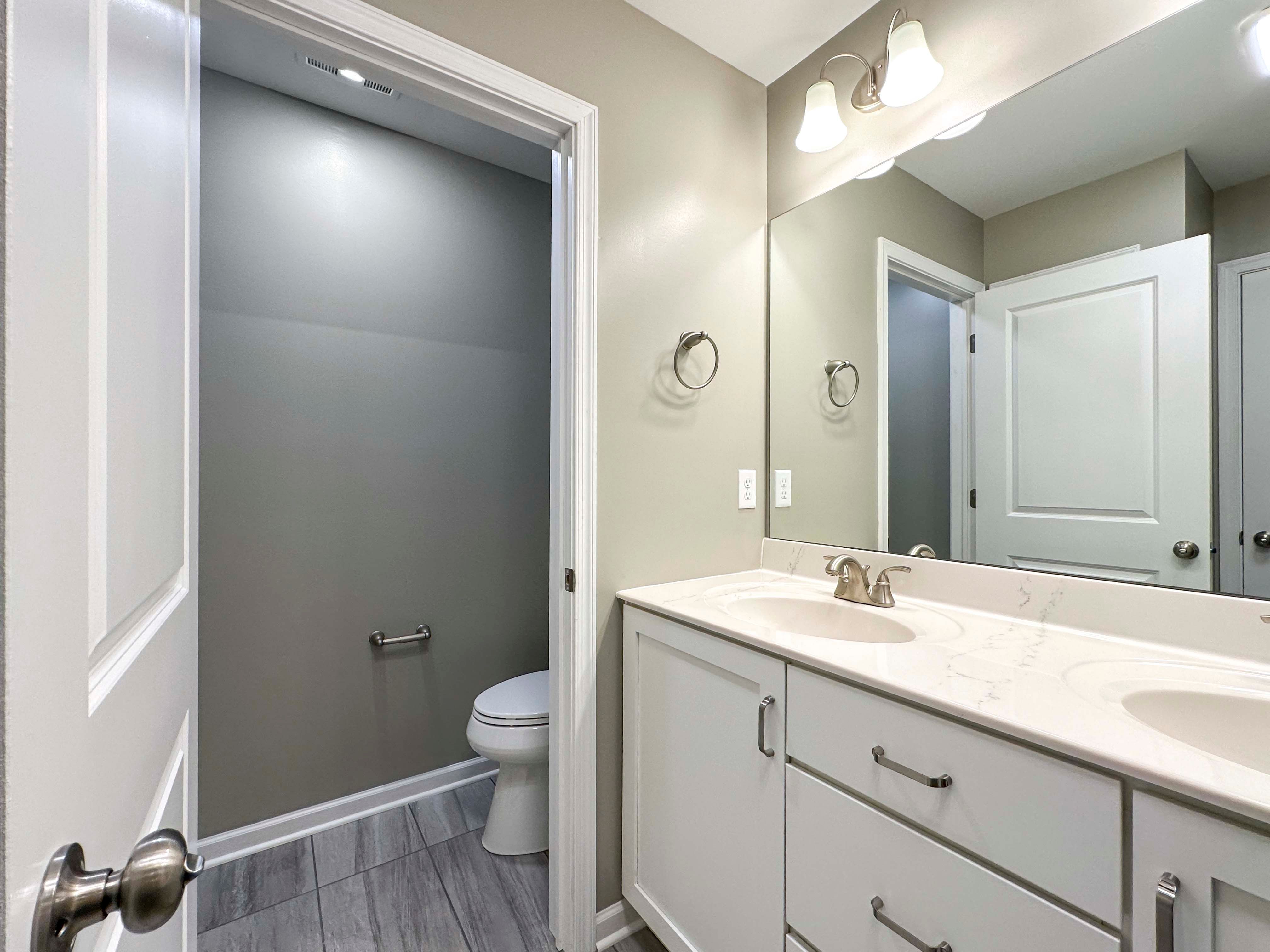 Bathroom with dual vanity and enclosed water closet