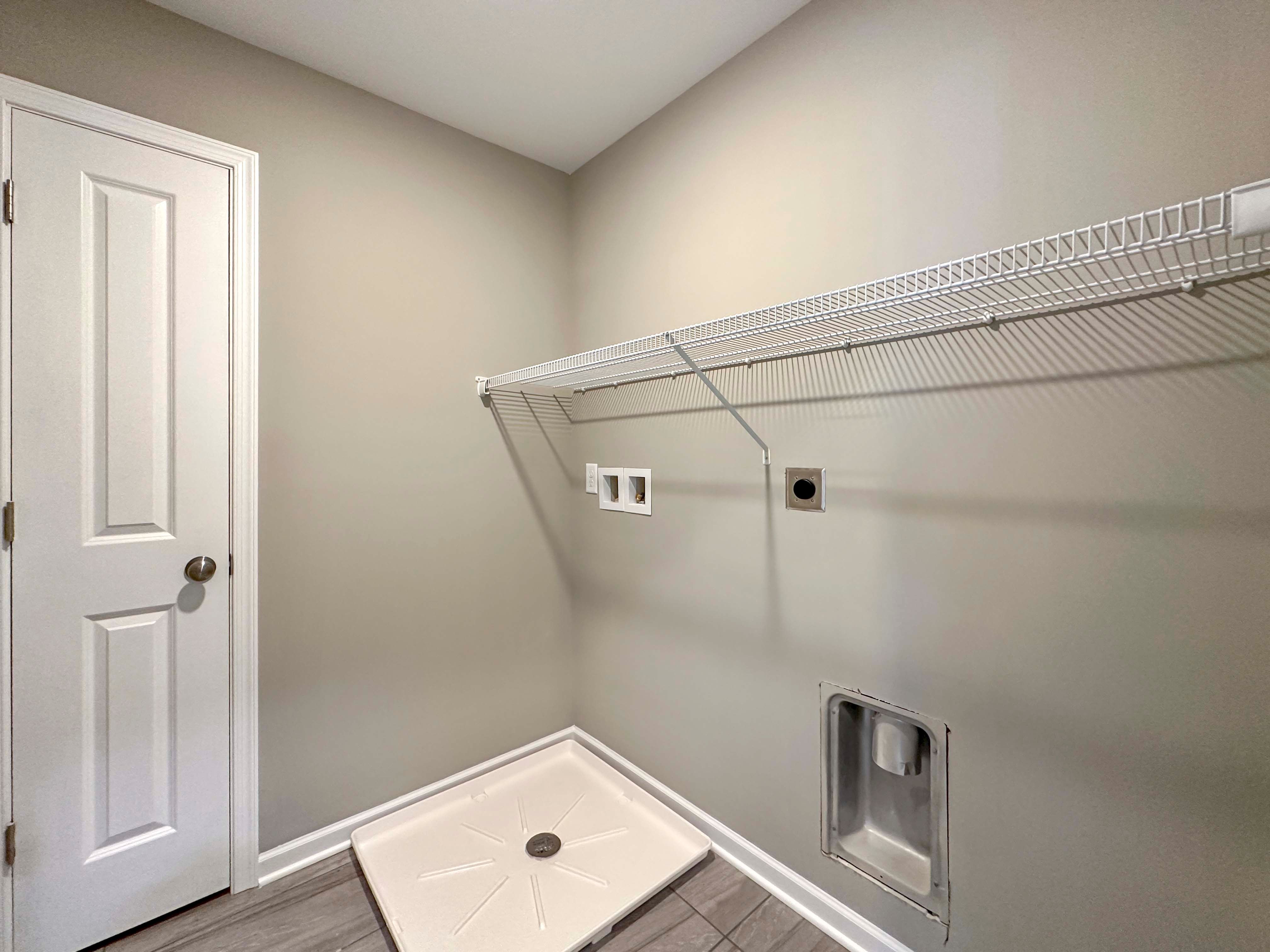 Laundry room with washer pan and wire shelving