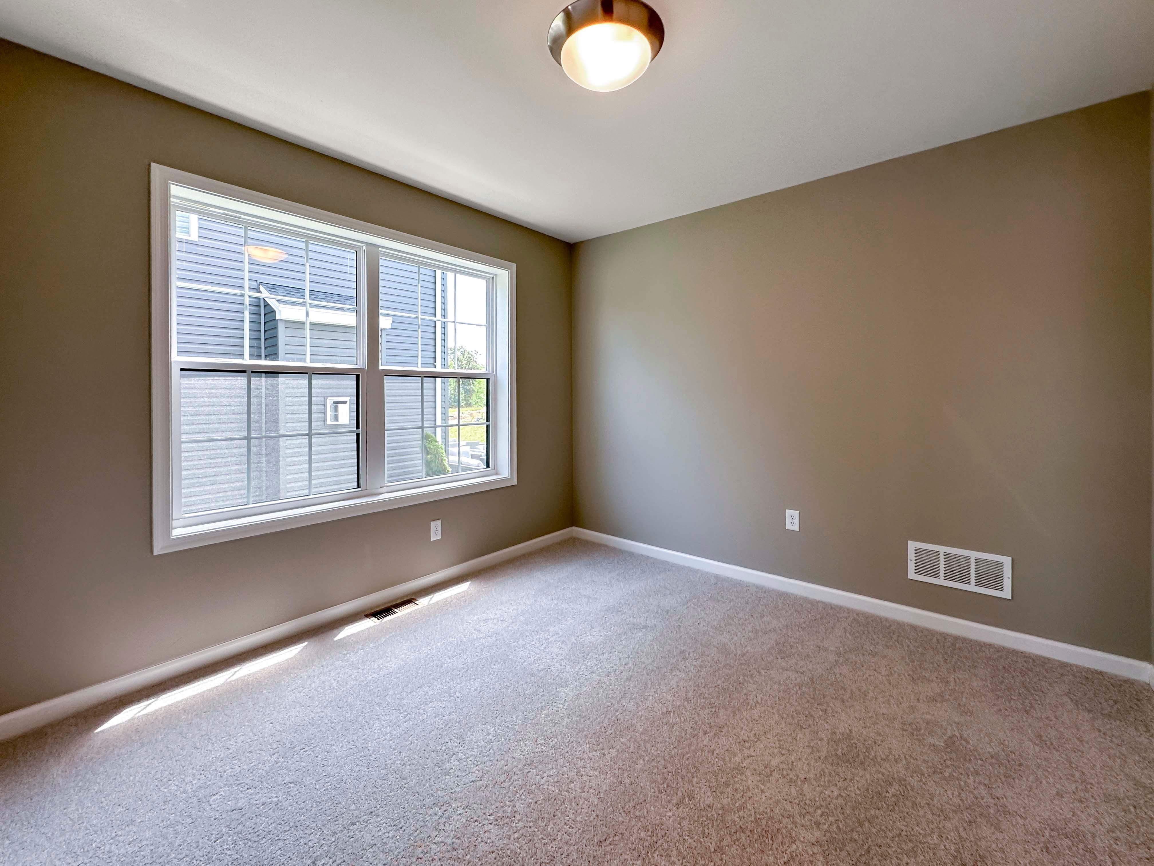 Unfurnished bedroom with carpet flooring and dual windows on side wall