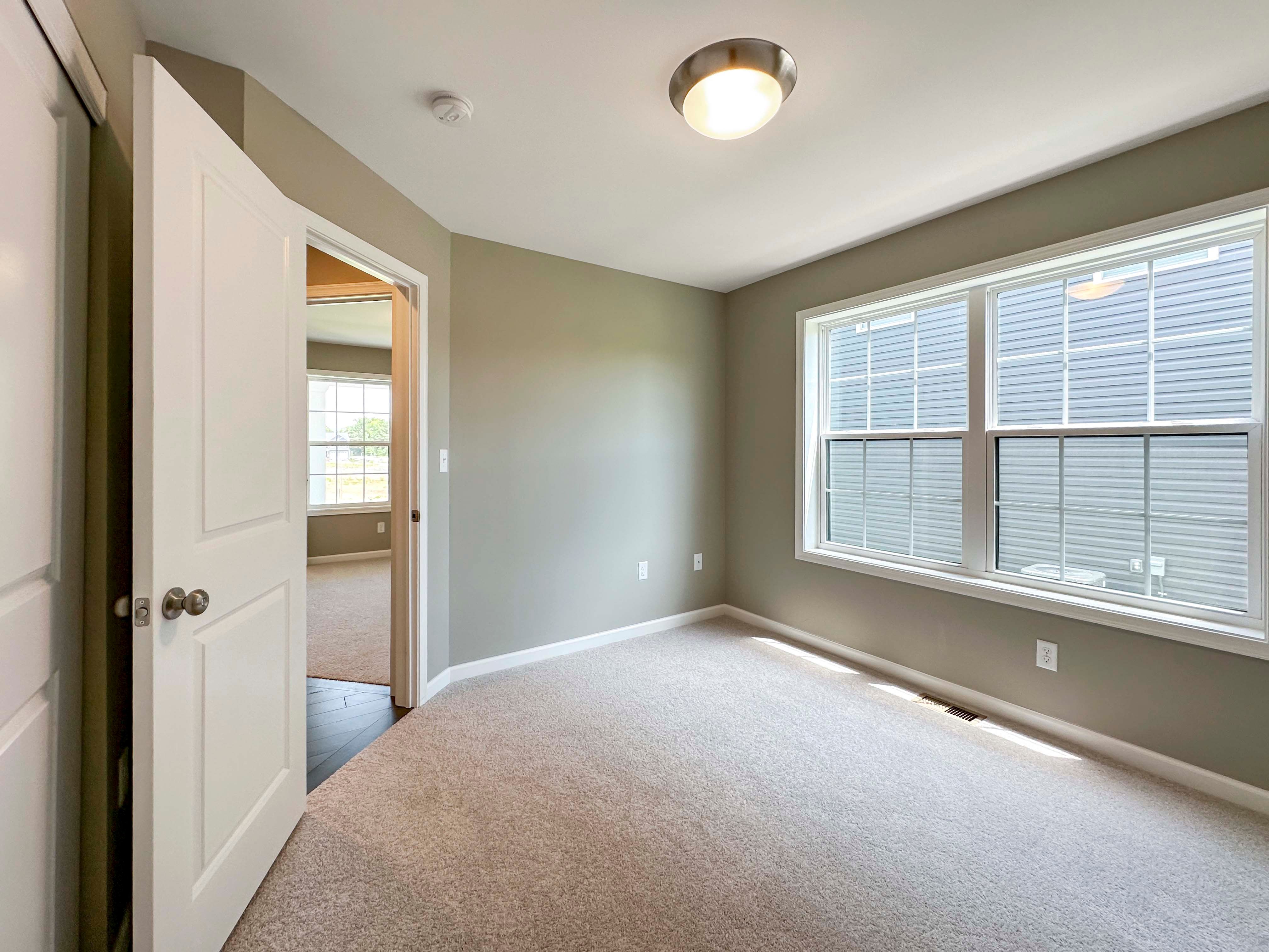 Unfurnished bedroom with carpet flooring and dual windows on side wall