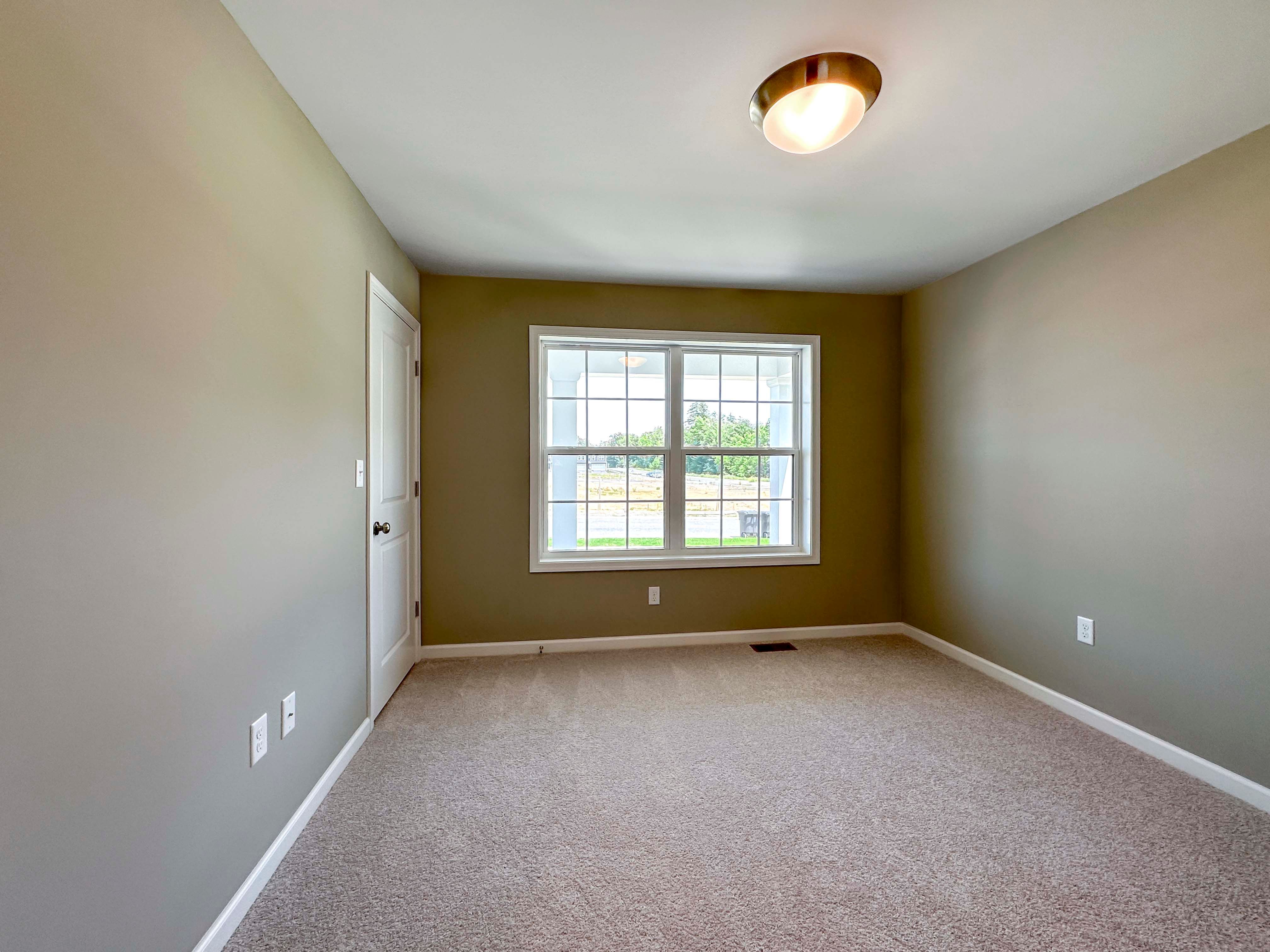 Unfurnished bedroom with carpet flooring and dual windows on front