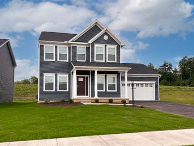 Fairmont- Front exterior - 2 story home with front porch, 2 car front entry attached garage, and vinyl siding.