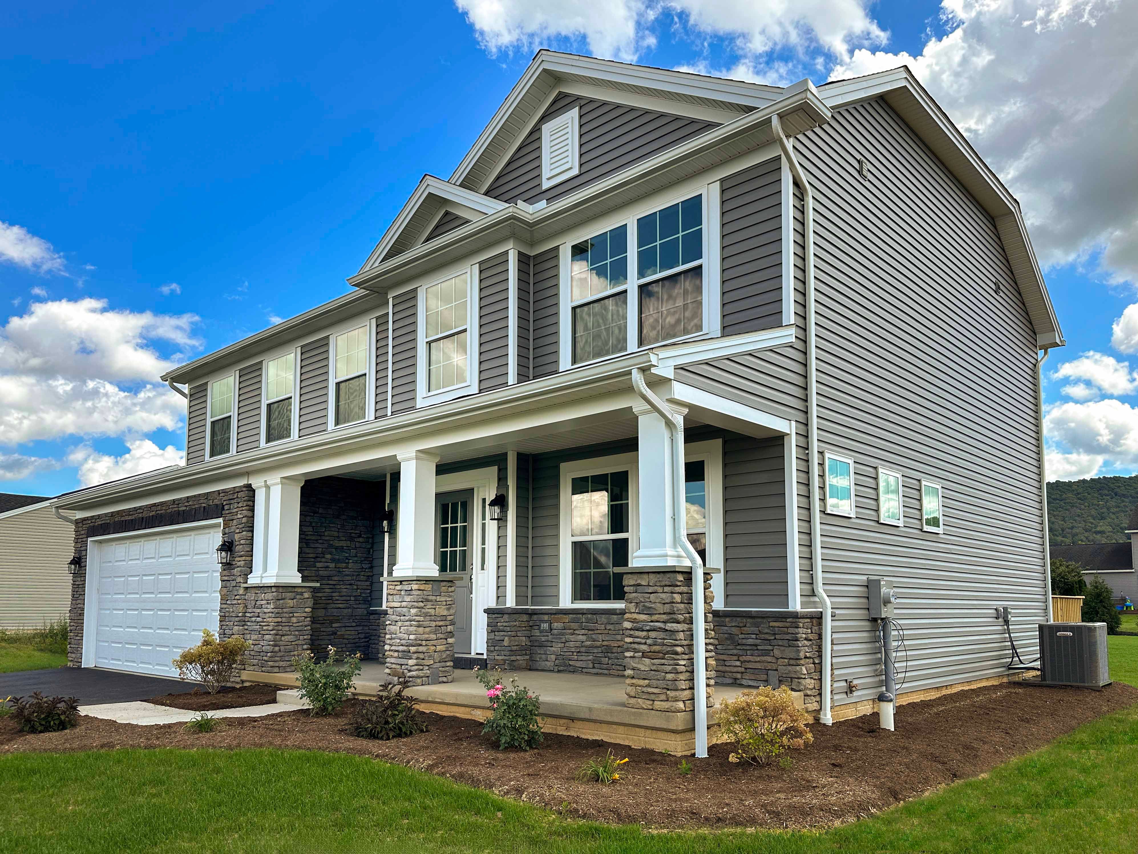 S&A Homes Greenwood floorplan - front exterior view - two story home with front porch, vinyl siding, and two car garage