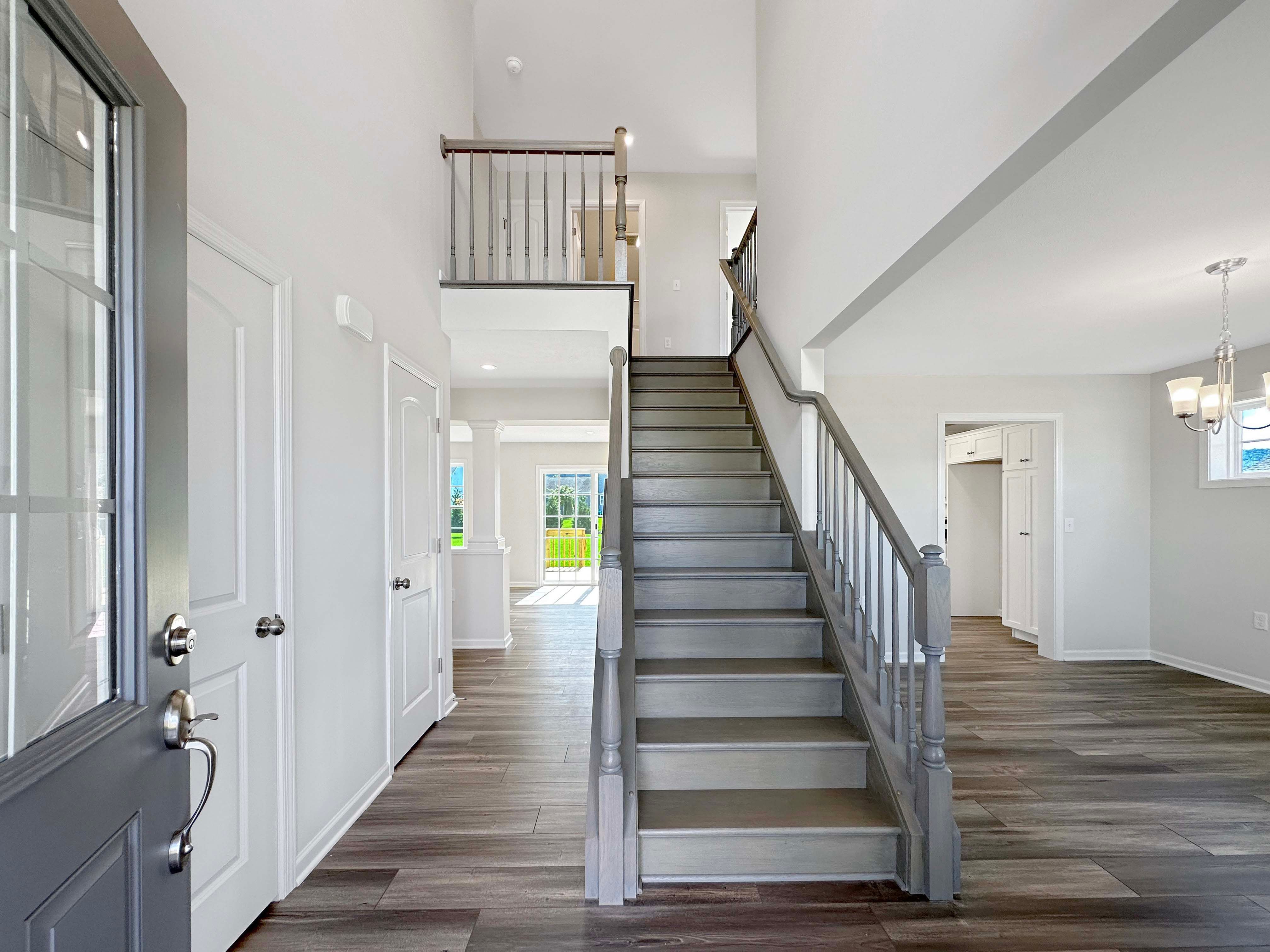 Entryway or foyer with staircase leading to 2nd floor - hallway on left side and dining area to the right.