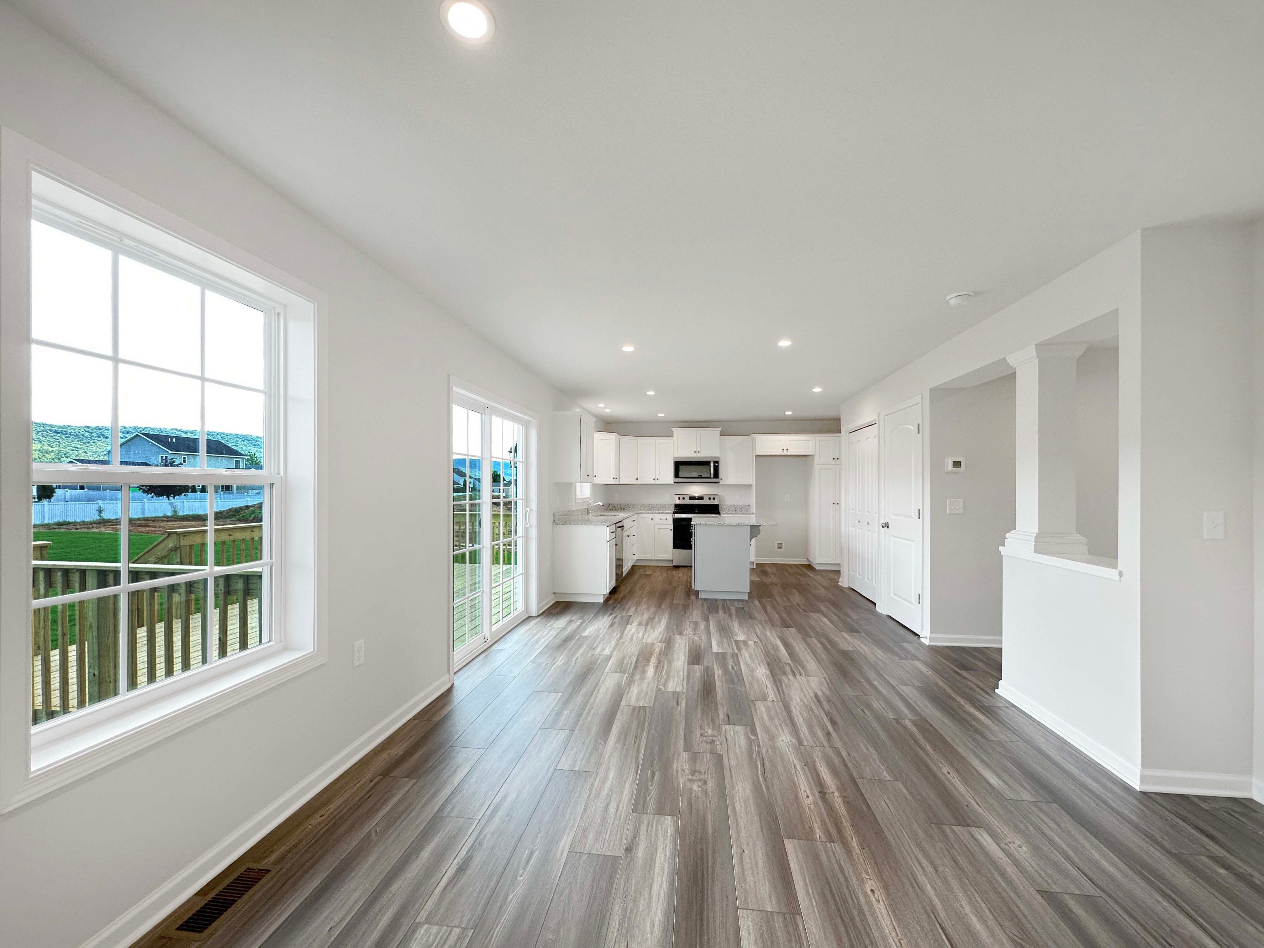 Family Room with LVT flooring, recessed lighting in ceiling, and one window on left wall - facing towards the Kitchen.