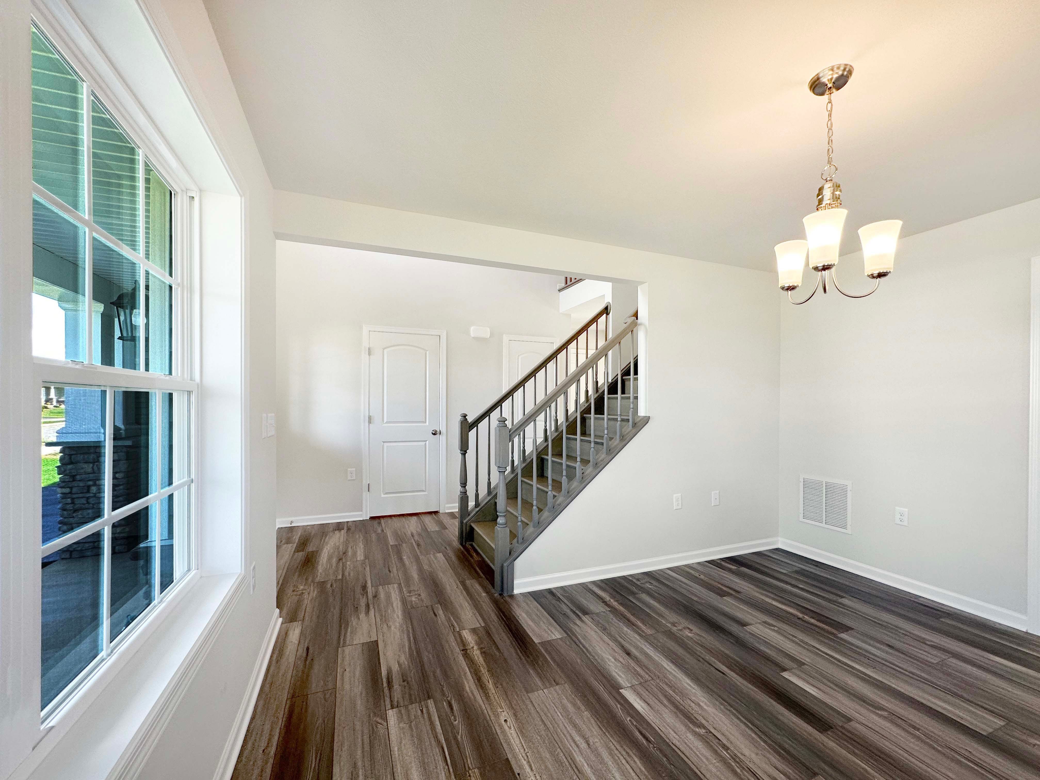Foyer and staircase to 2nd floor from Dining Room. Pendant Light and LVT flooring.