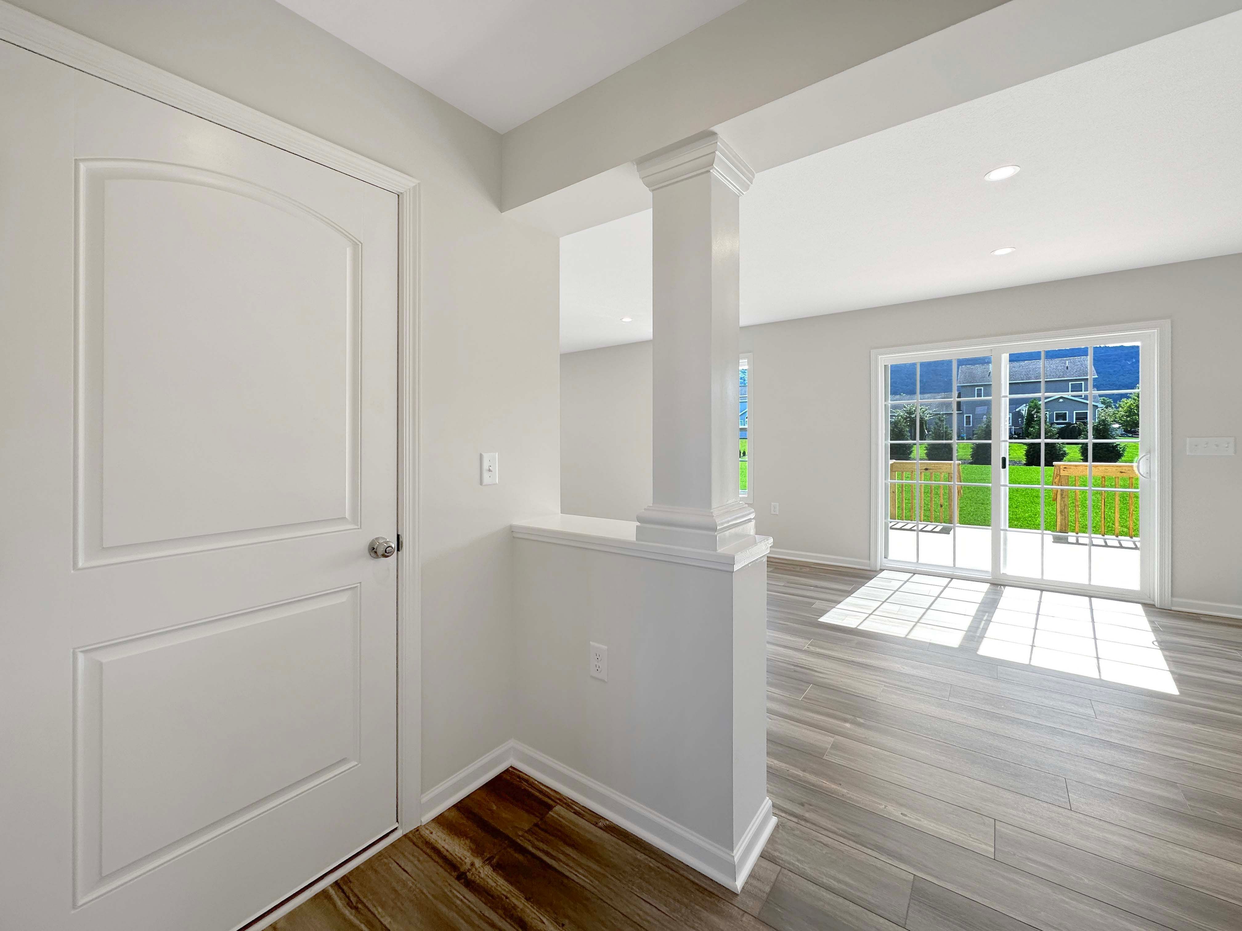 Hallway into Family Room and Kitchen area - sliding glass door to patio on rear wall. Door on left enters to garage.
