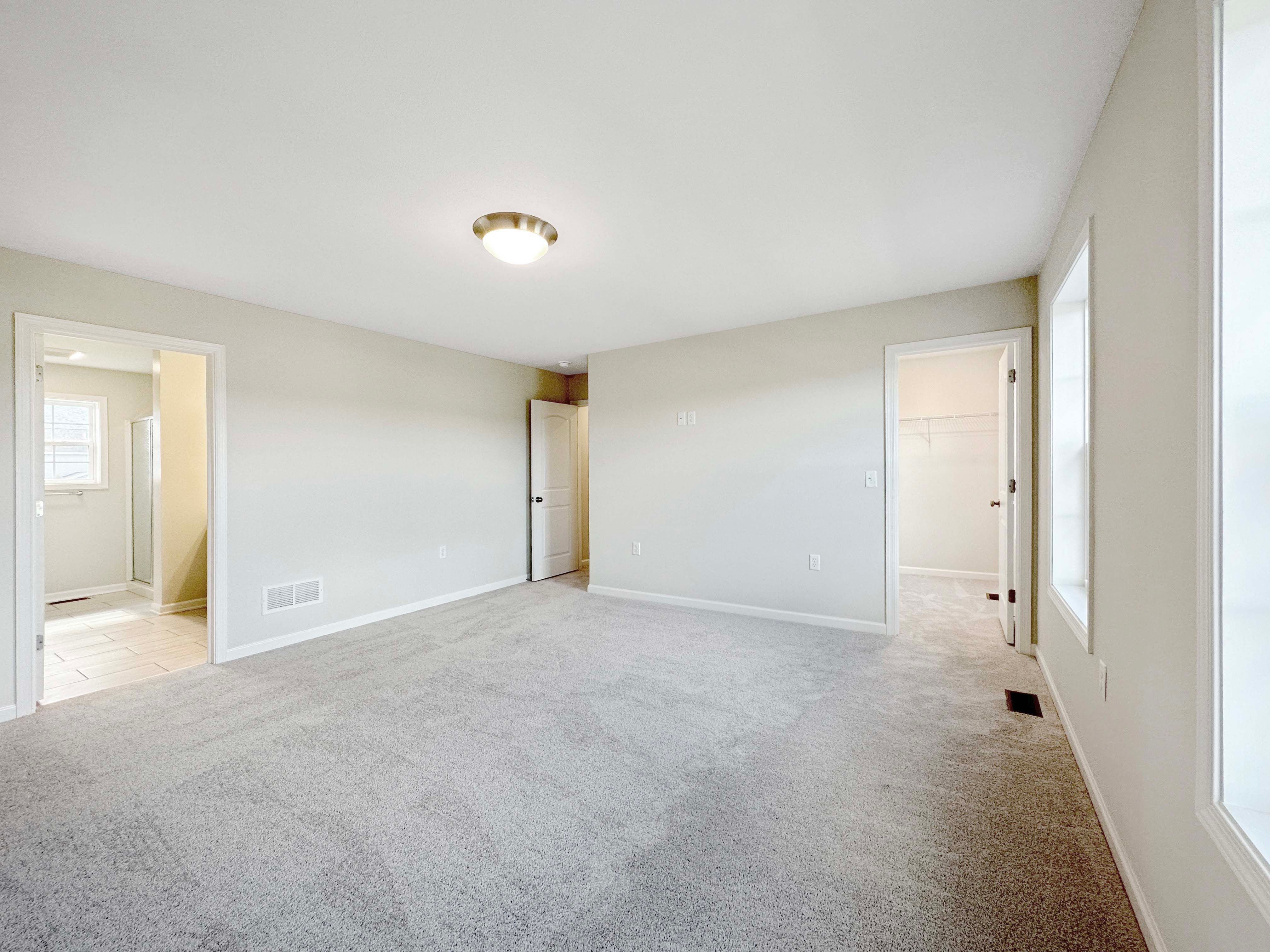 Owner's bedroom with entrance to walk-in closet and owner's bathroom.