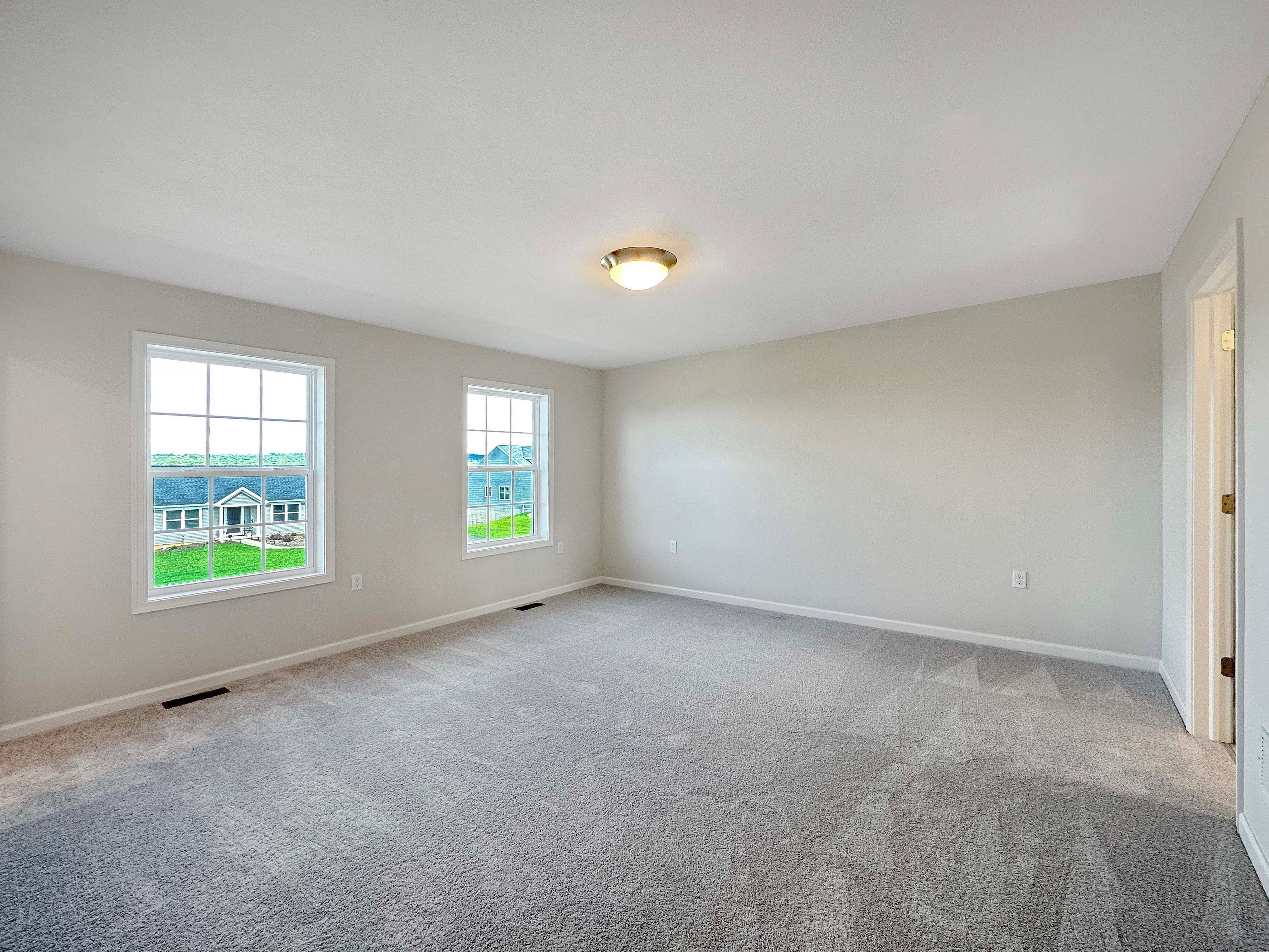 Bedroom with plush carpeting, windows, and closet.