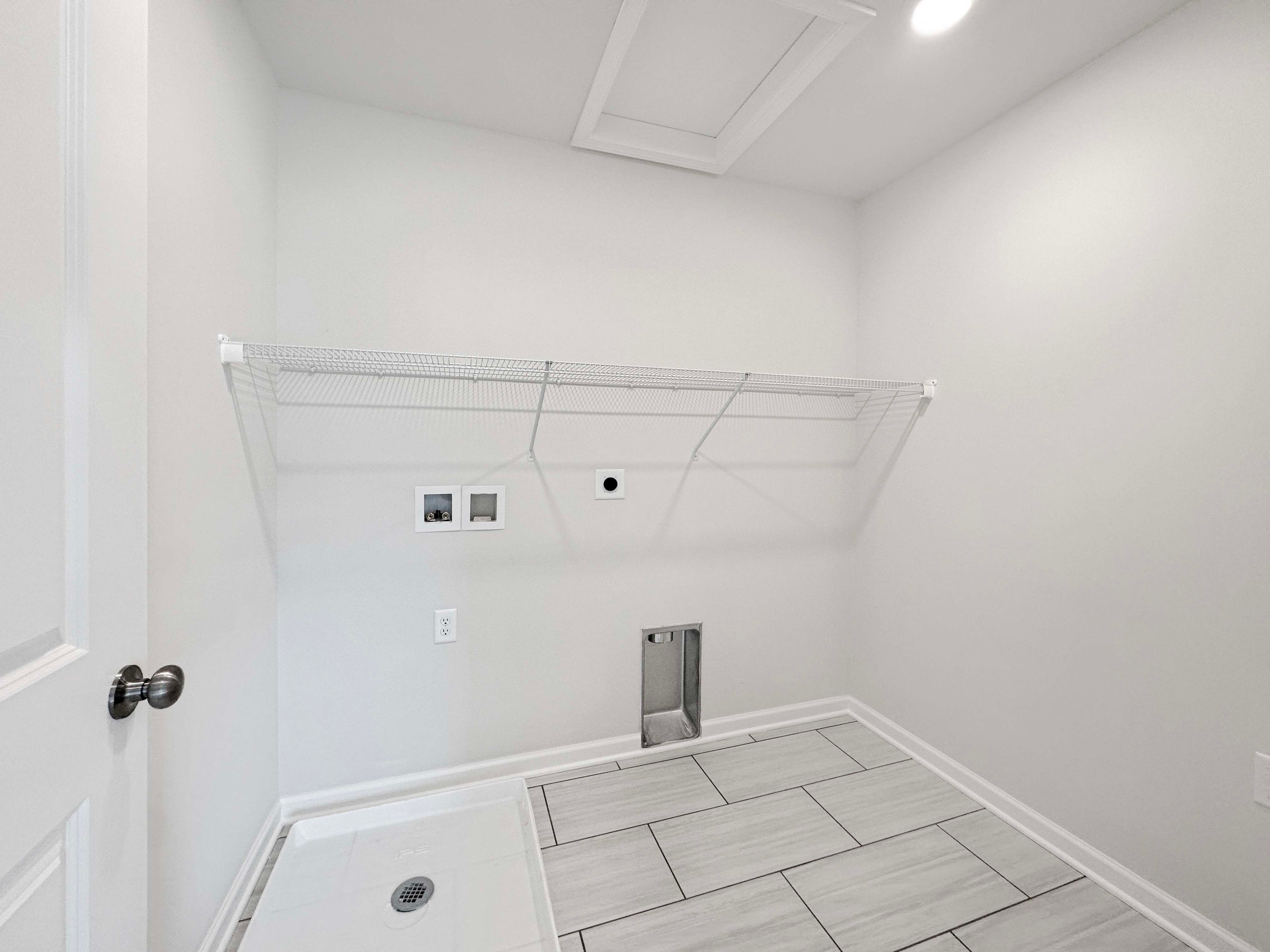 2nd floor laundry with washer/dryer hook-up, wire shelving, and ceramic tile flooring.