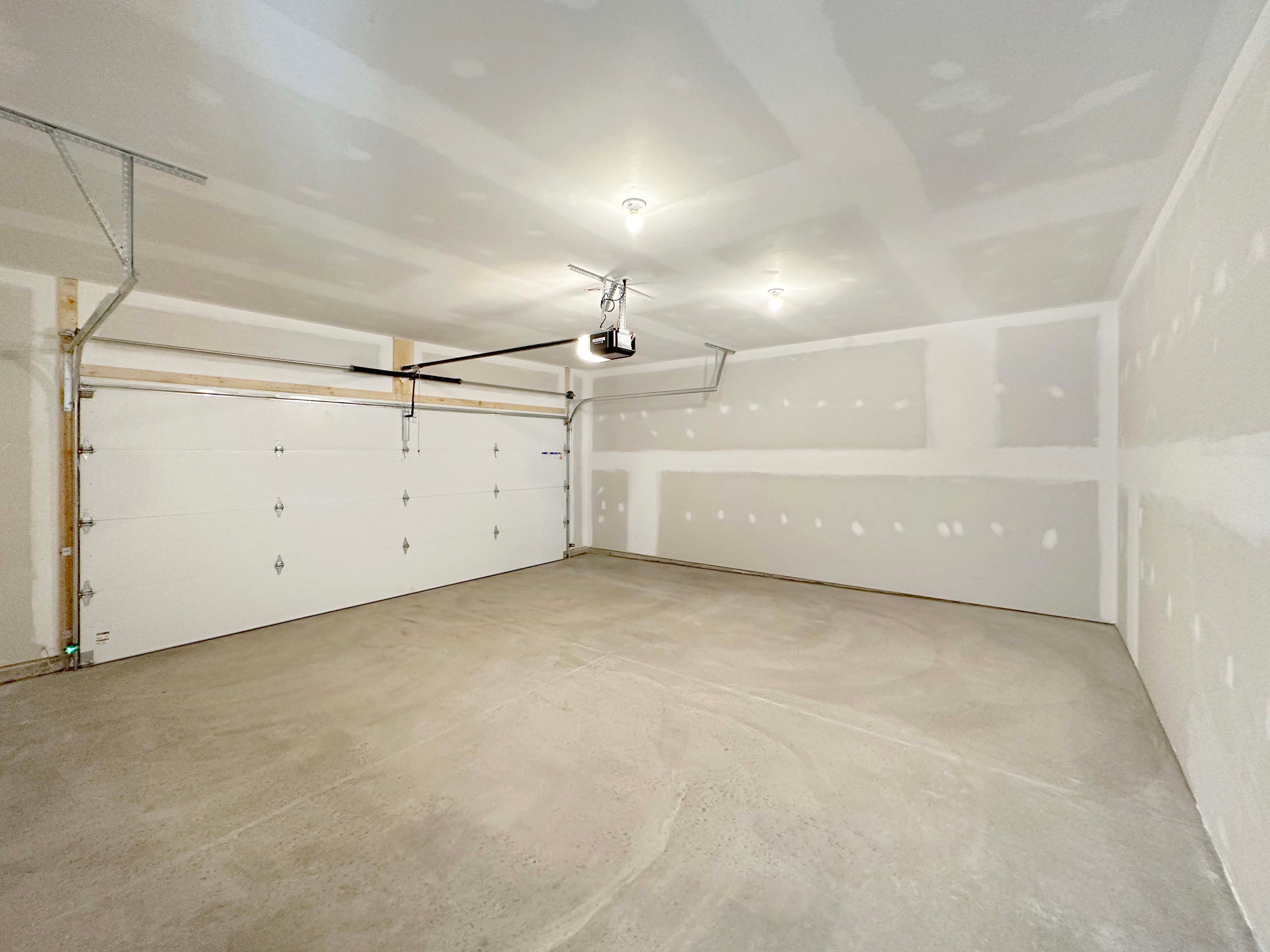 Two car garage with garage door on left hand side.