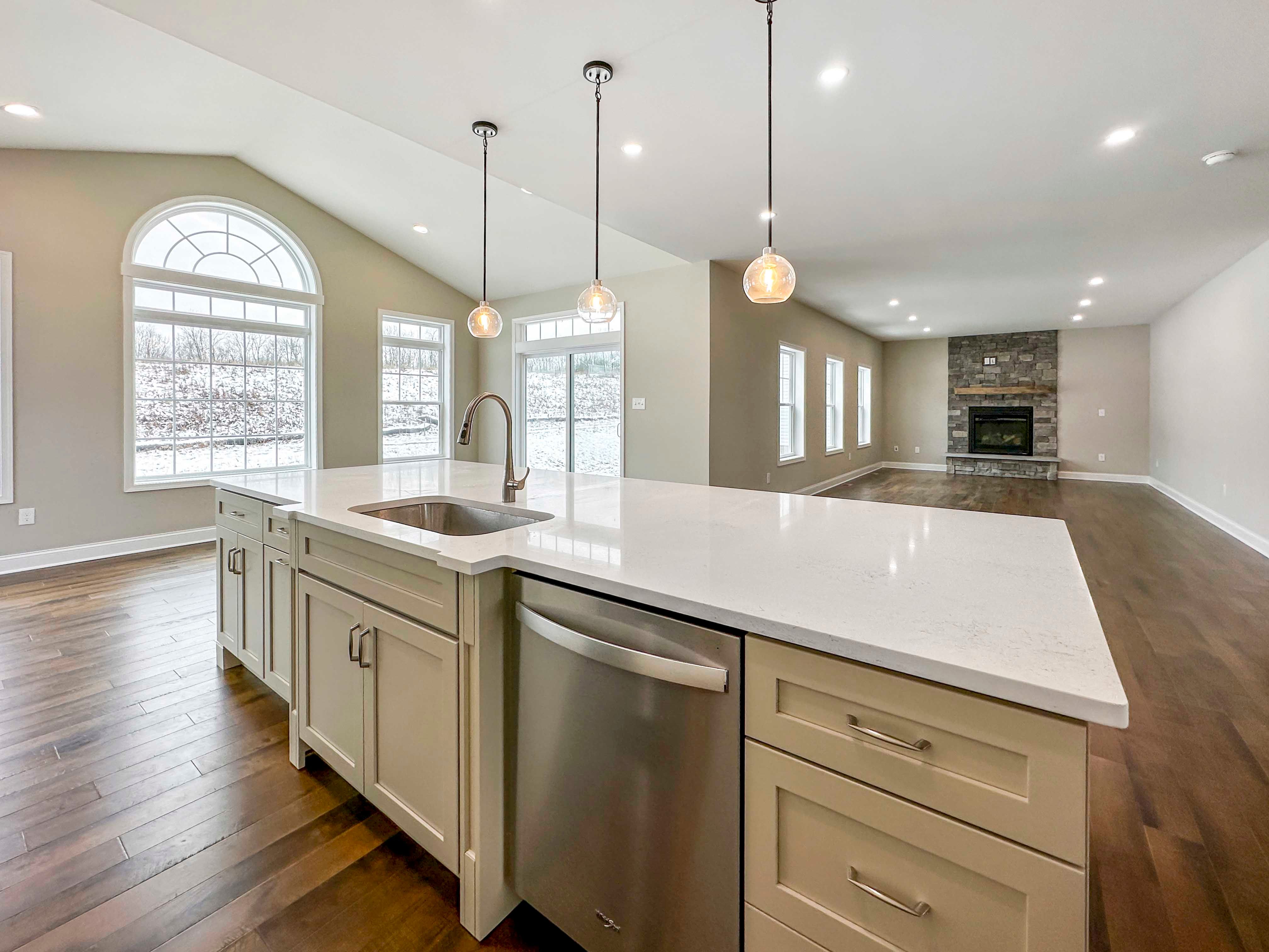 Kitchen Island - with white cabinetry, built-in stainless dishwasher, single-basin sink, and overhead pendant lighting. Opt. Keeping Room to the left and Family Room to the right in the rear.