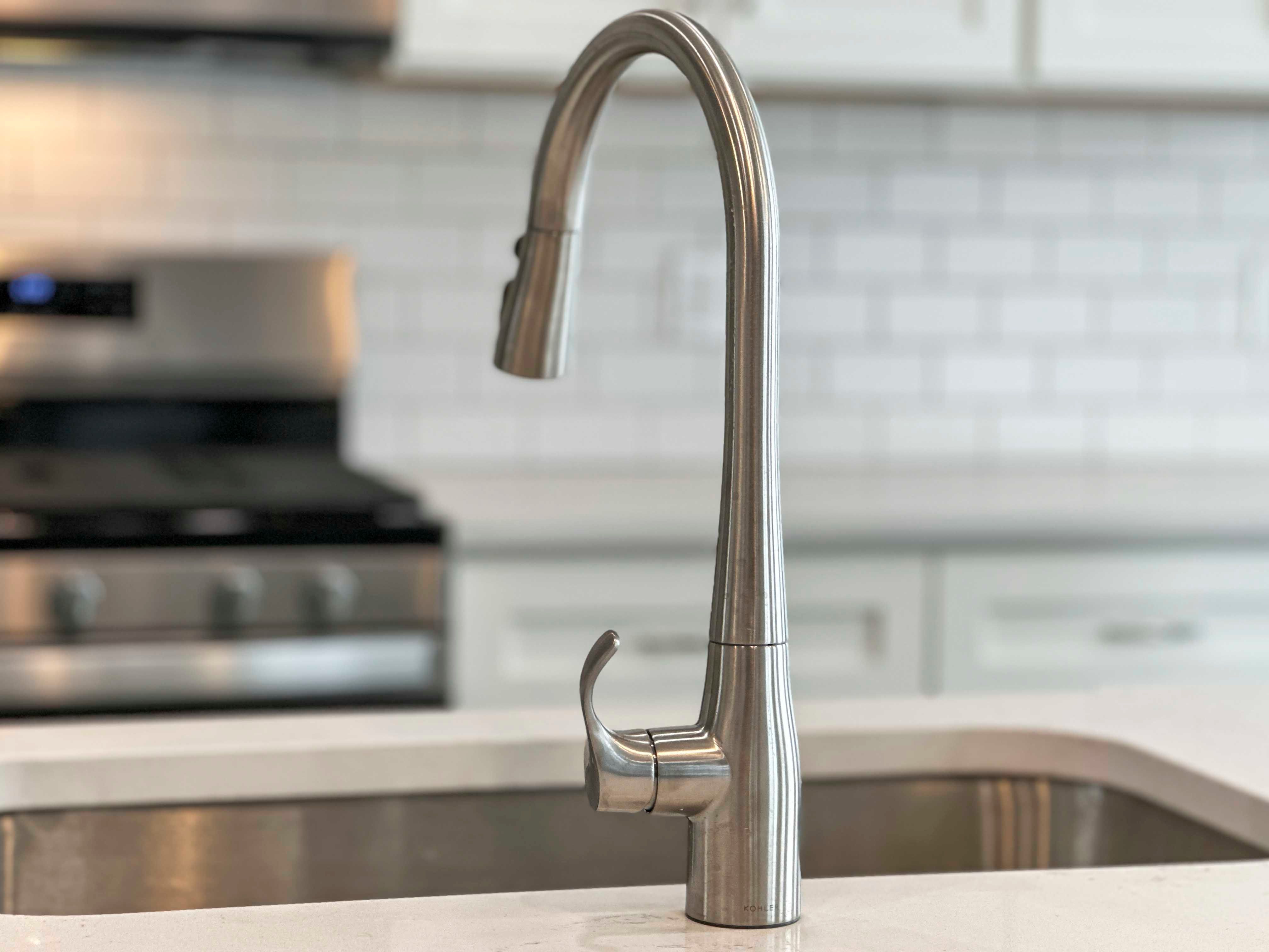 Kitchen - single bowl sink with single-lever faucet. White cabinetry and countertops.