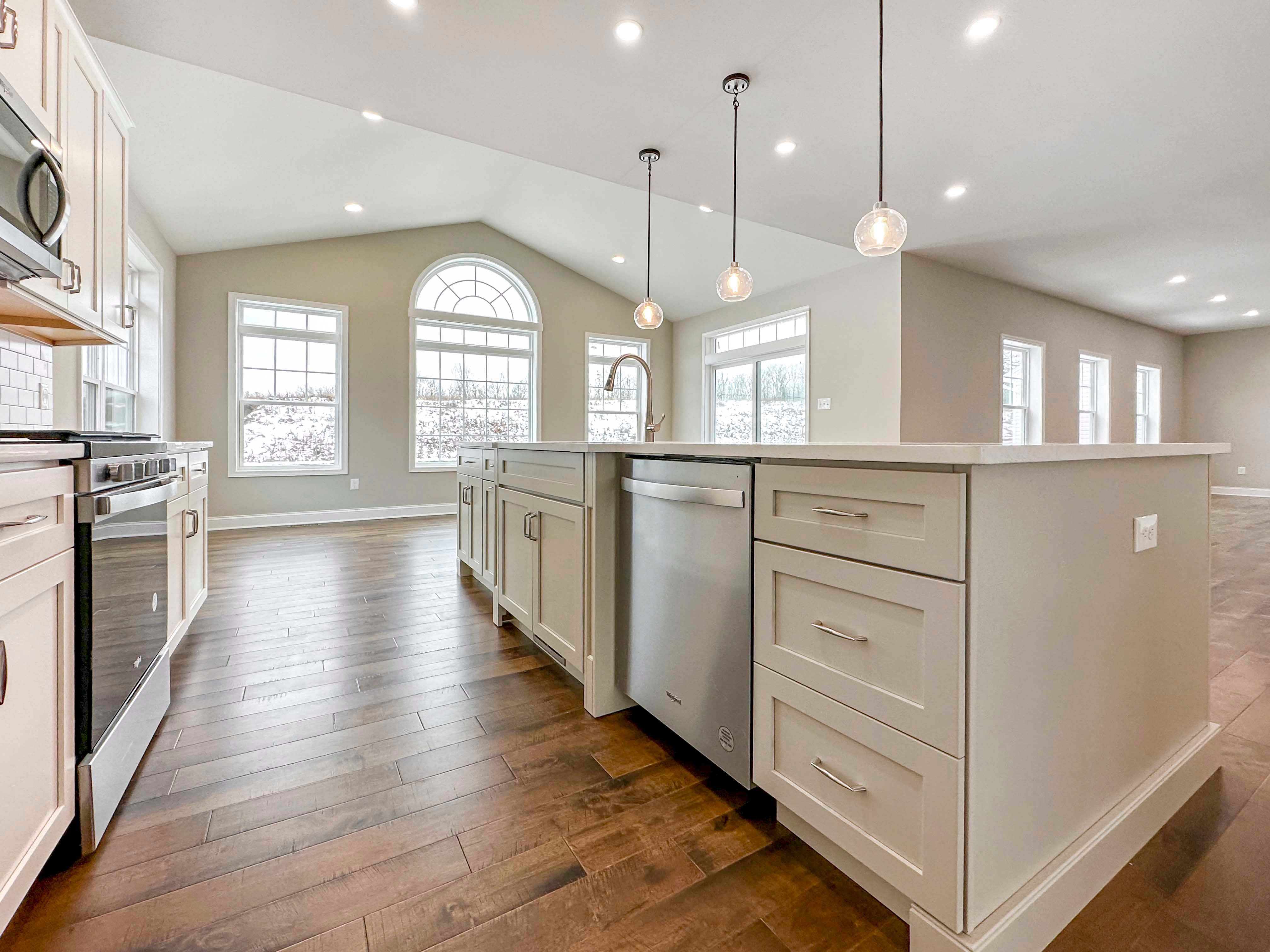 Kitchen Island - with white cabinetry, built-in stainless dishwasher, single-basin sink, and overhead pendant lighting above island. Opt. Keeping Room to the left and Family Room to the right in the rear, recessed lighting throughout.