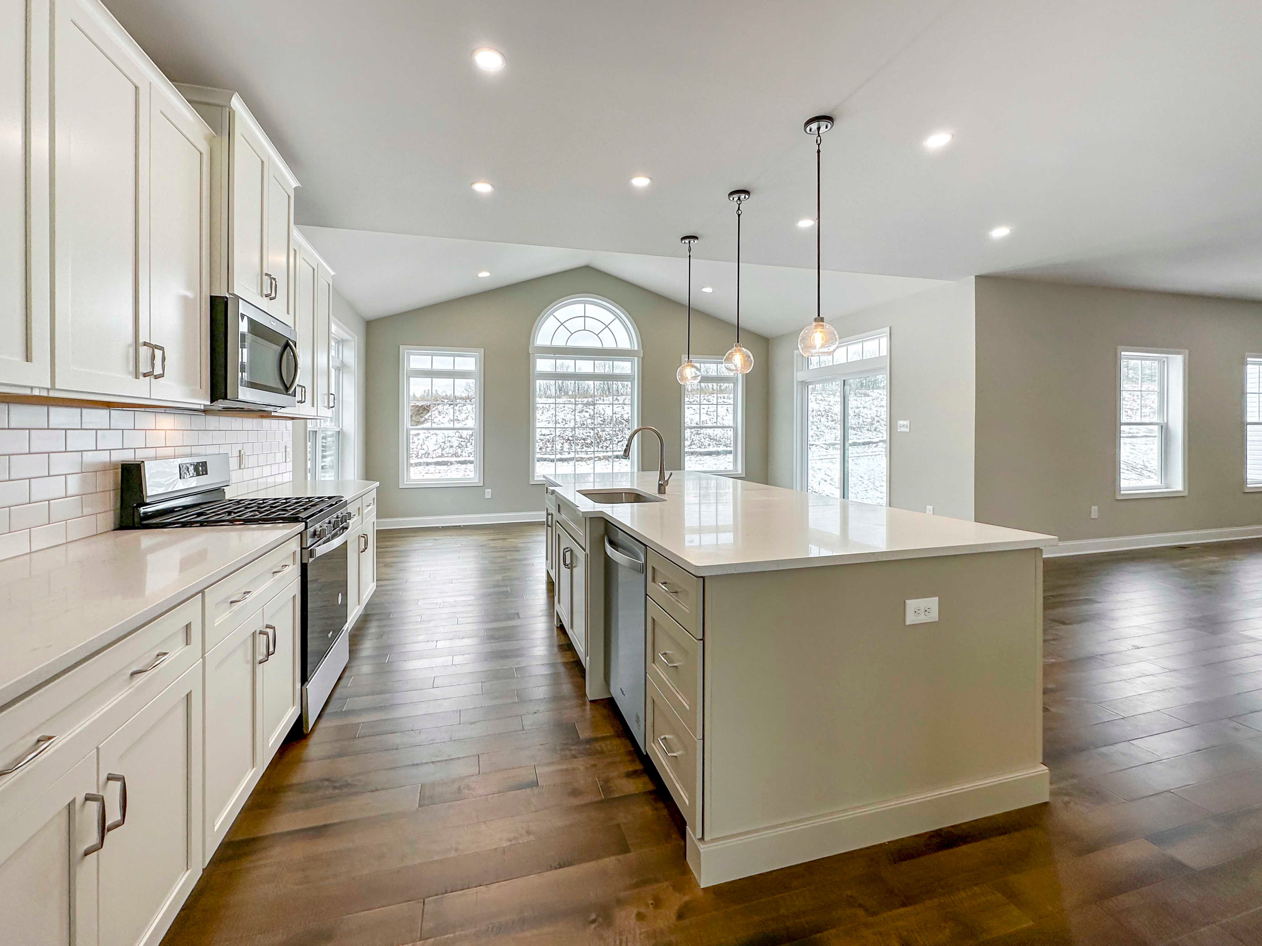 Kitchen - with white cabinetry, built-in stainless dishwasher, single-basin sink, and overhead pendant lighting above island. Opt. Keeping Room to the rear with additional recessed lighting.