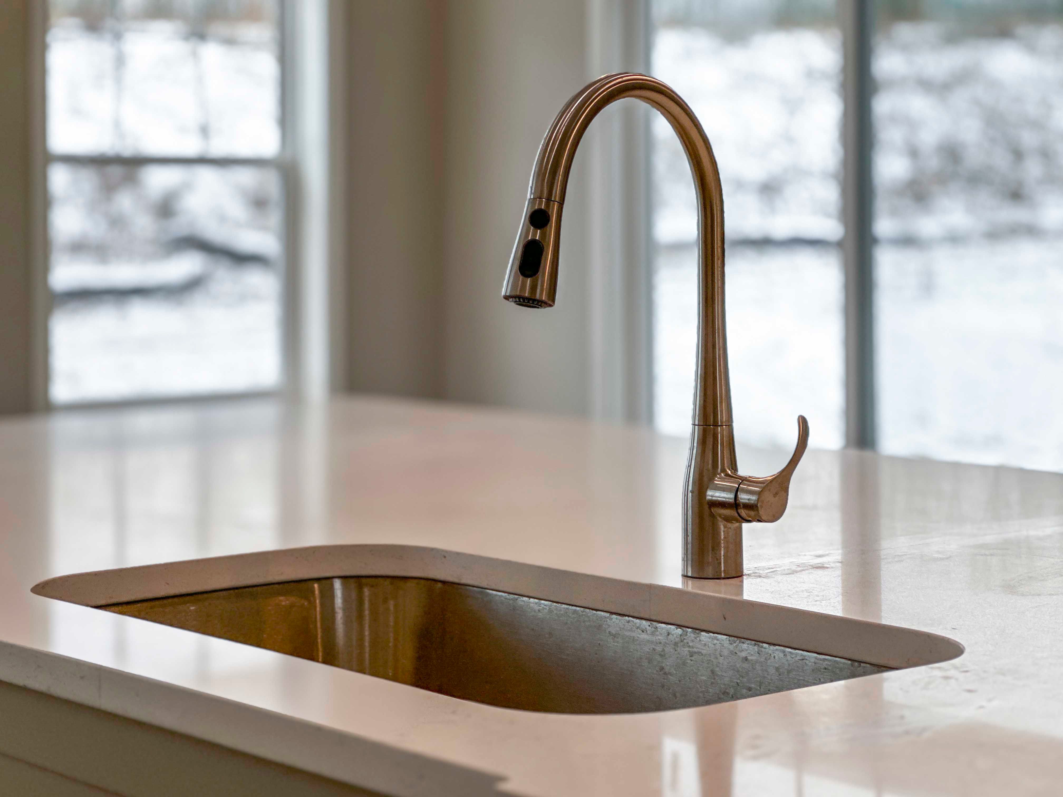 Kitchen - single bowl sink with single-lever faucet. White cabinetry and countertops.