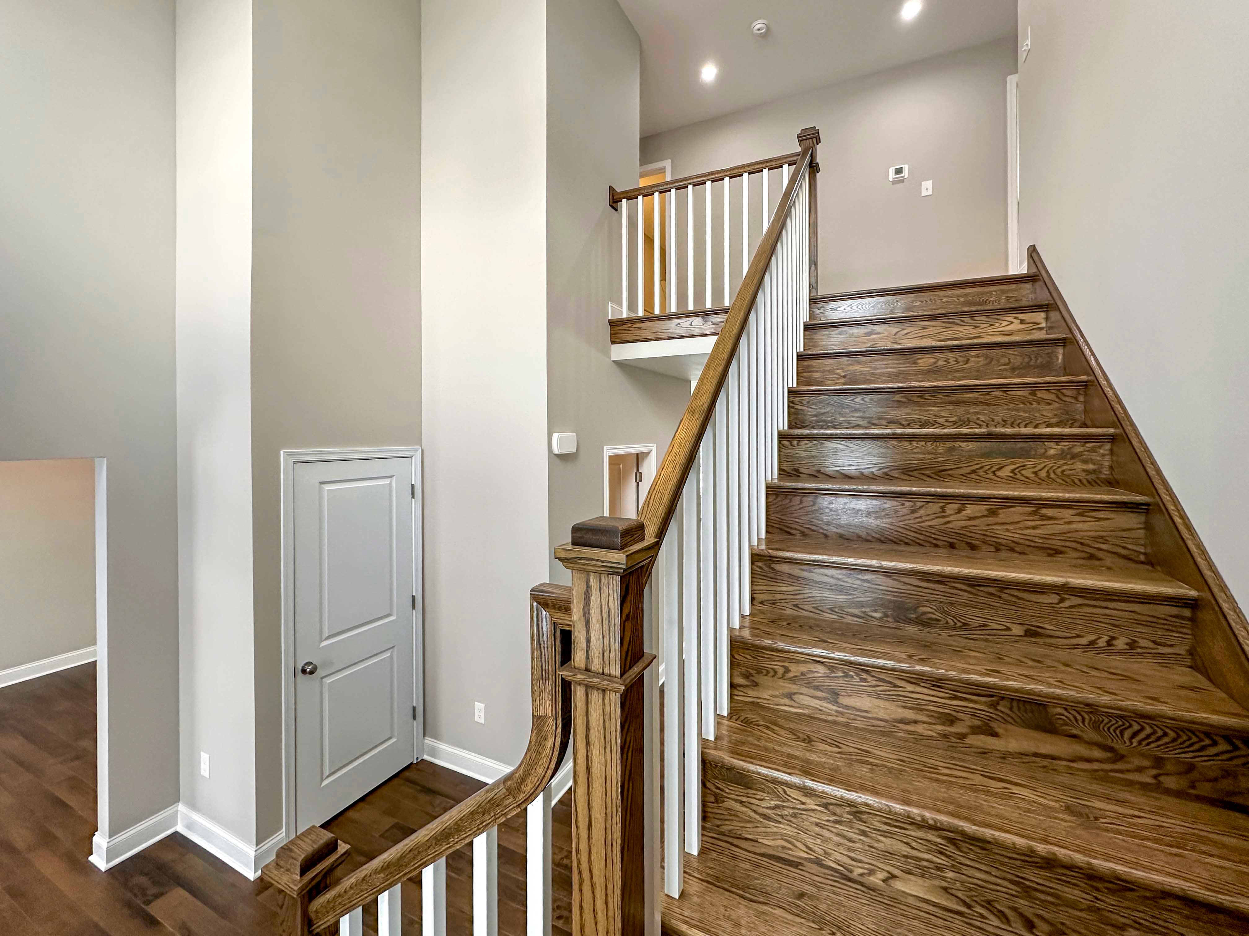 Staircase to Second floor - entrance to Dining Room on far left, Linen Closet door, remaining hardwood stairs lead up to second floor landing.