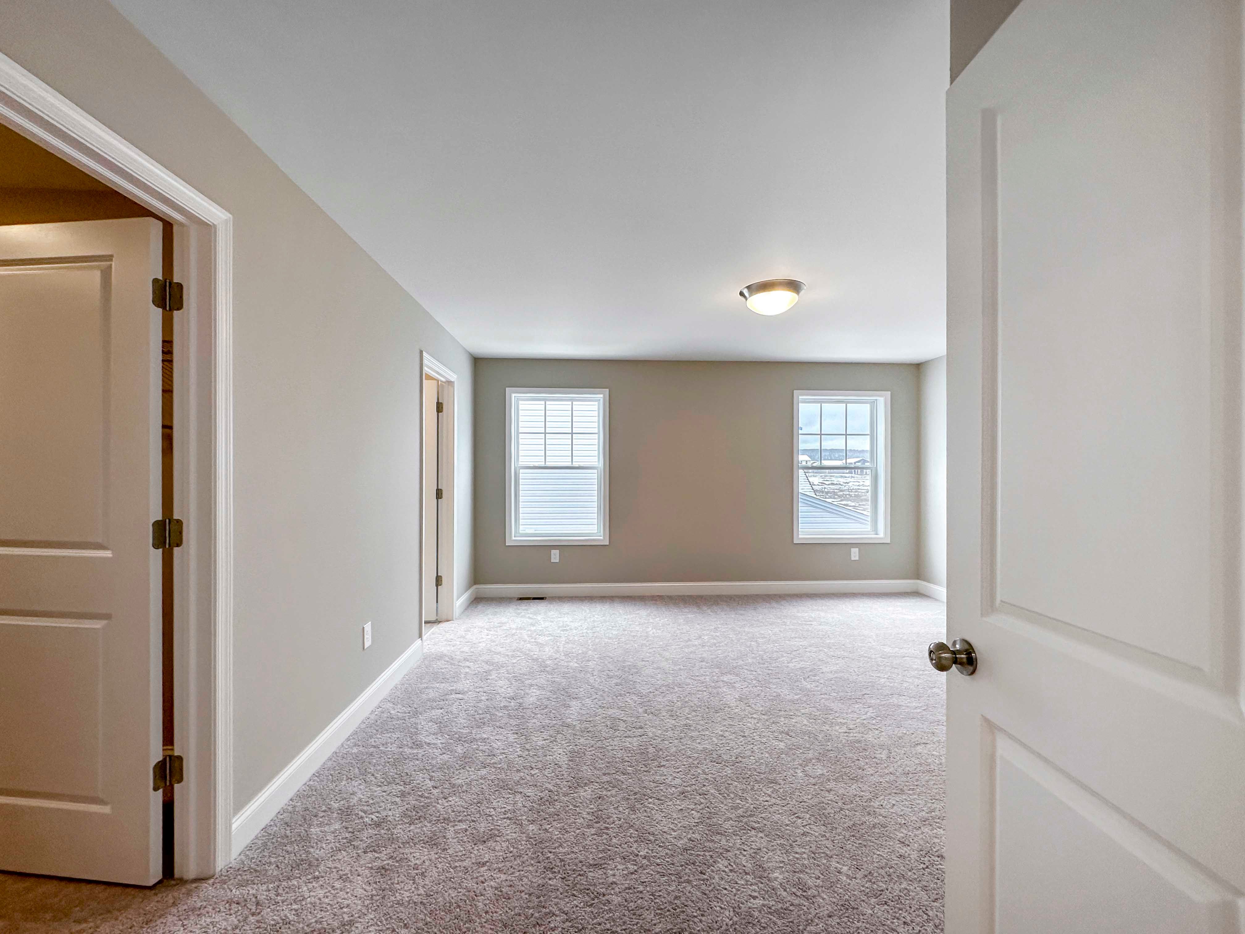 Owner's Bedroom - first door on left is walk-in closet, next door on left is entrance to Ensuite. Two single-hung windows on far wall.