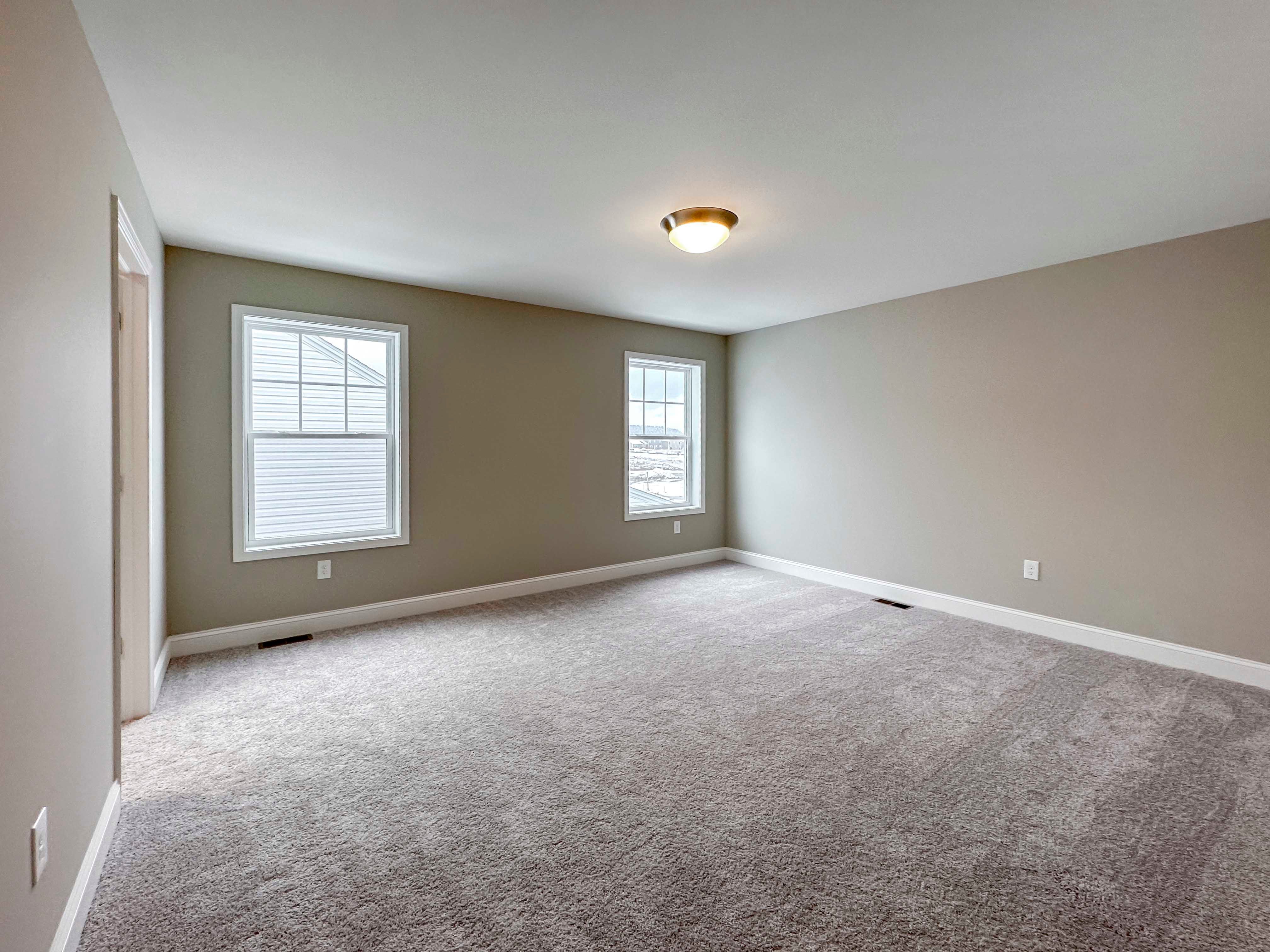 Owner's Bedroom - entrance to ensuite and single hung windows, plush carpet flooring.