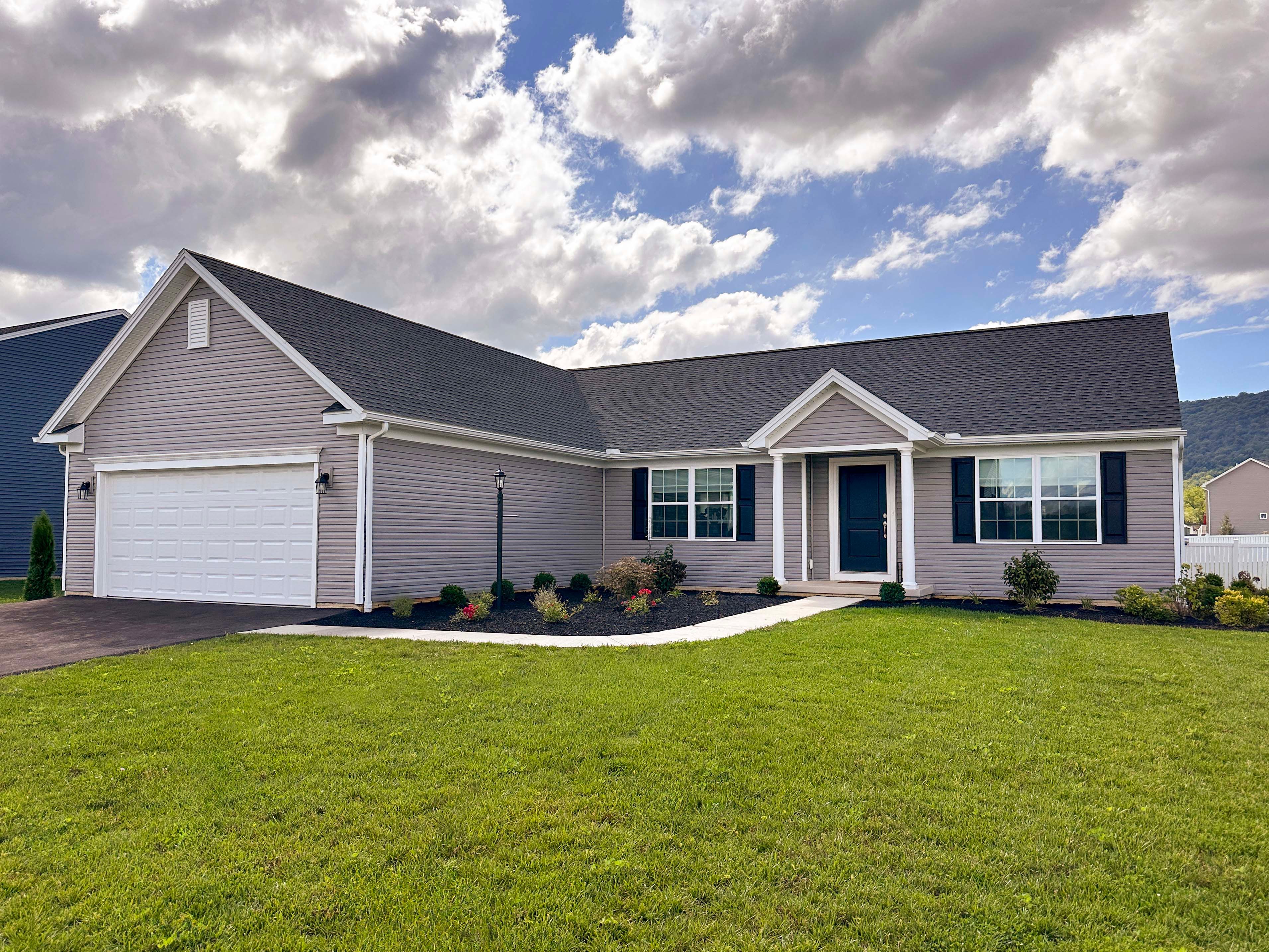 Ranch style home with vinyl siding and two car garage.