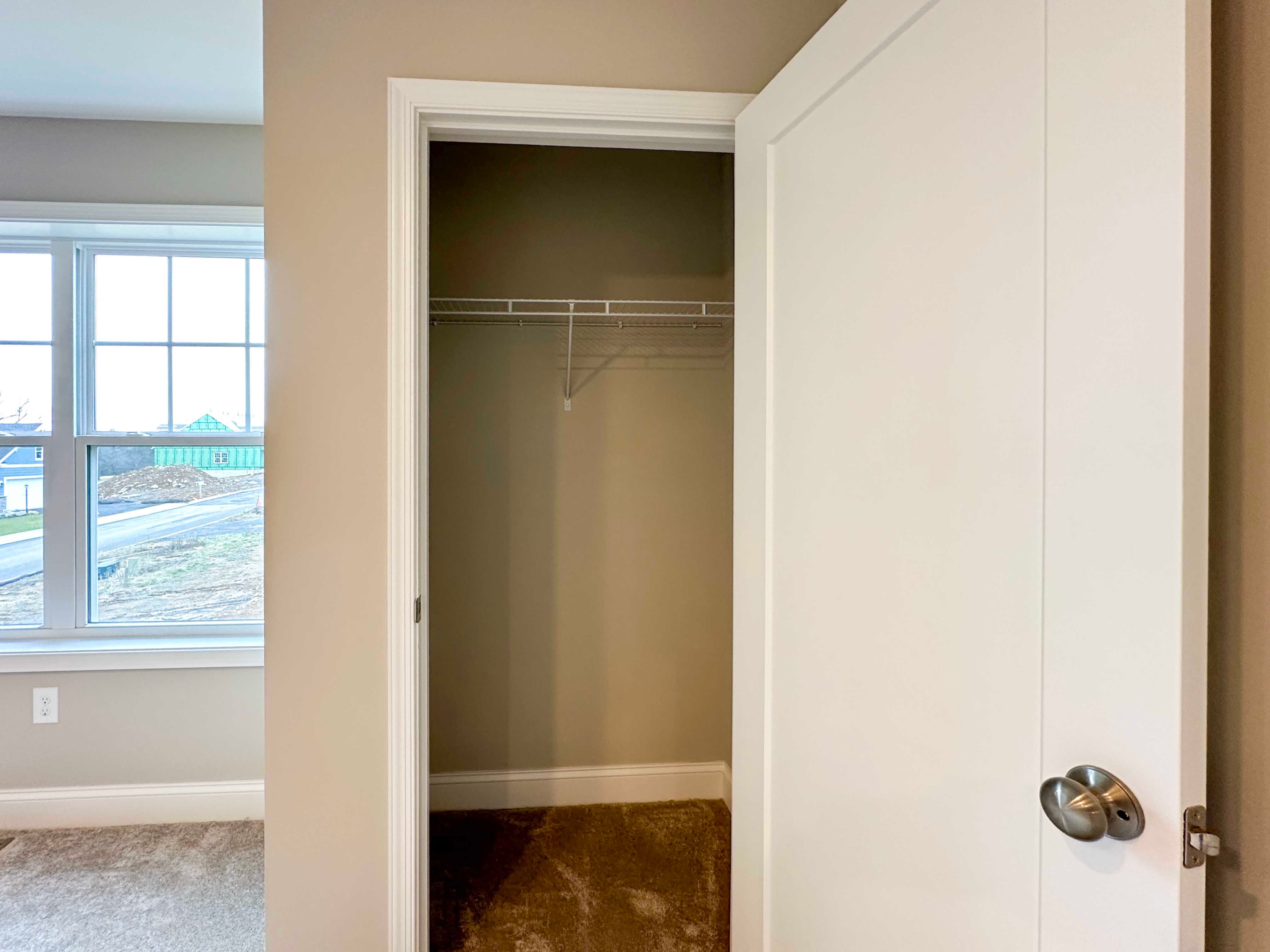 Bedroom 3 - closet with wire shelving, double window to left