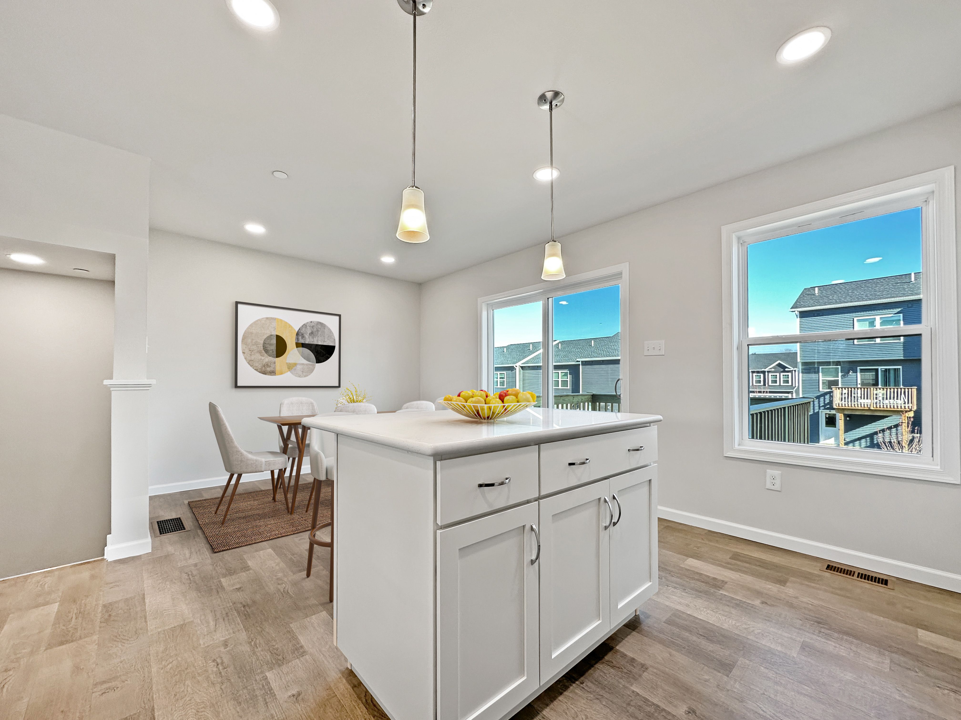Contemporary kitchen island with bar stools and pendant lights.
