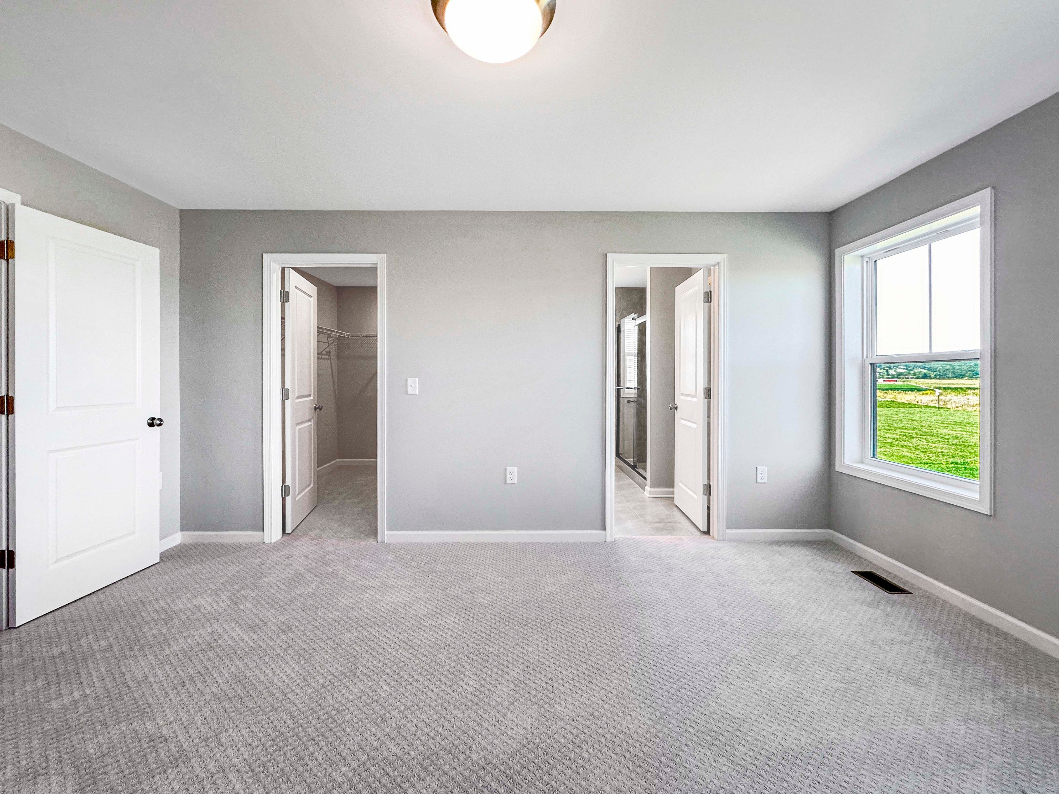 Bright and spacious owners bedroom with large windows and open access to the ensuite bath and walk-in closet.