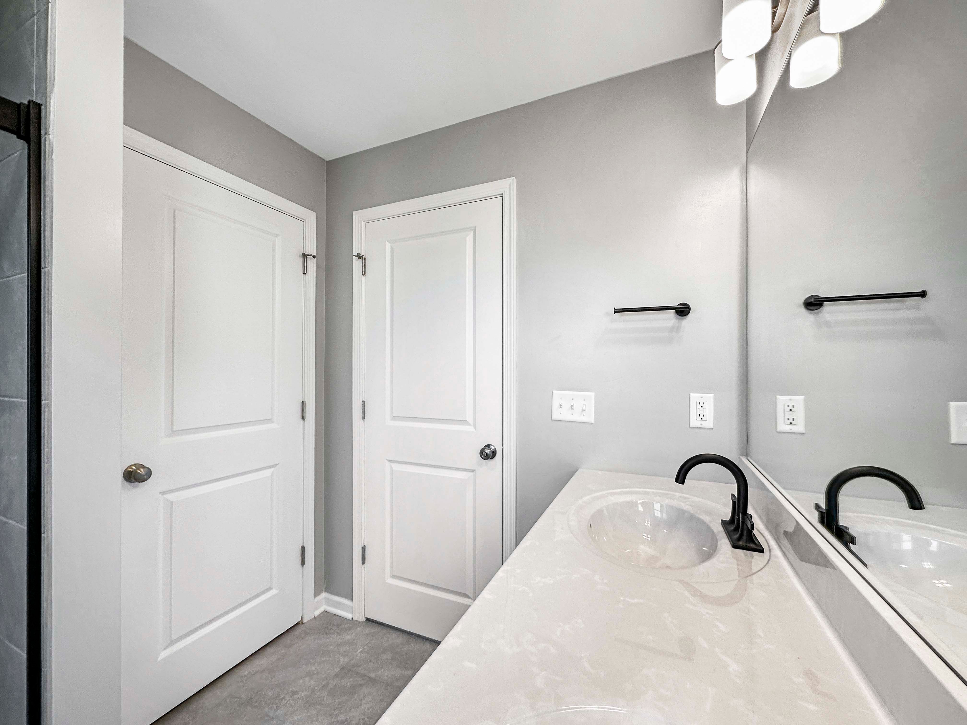 Spacious tile shower with glass doors, featuring a recessed shelf with herringbone tile detail.
