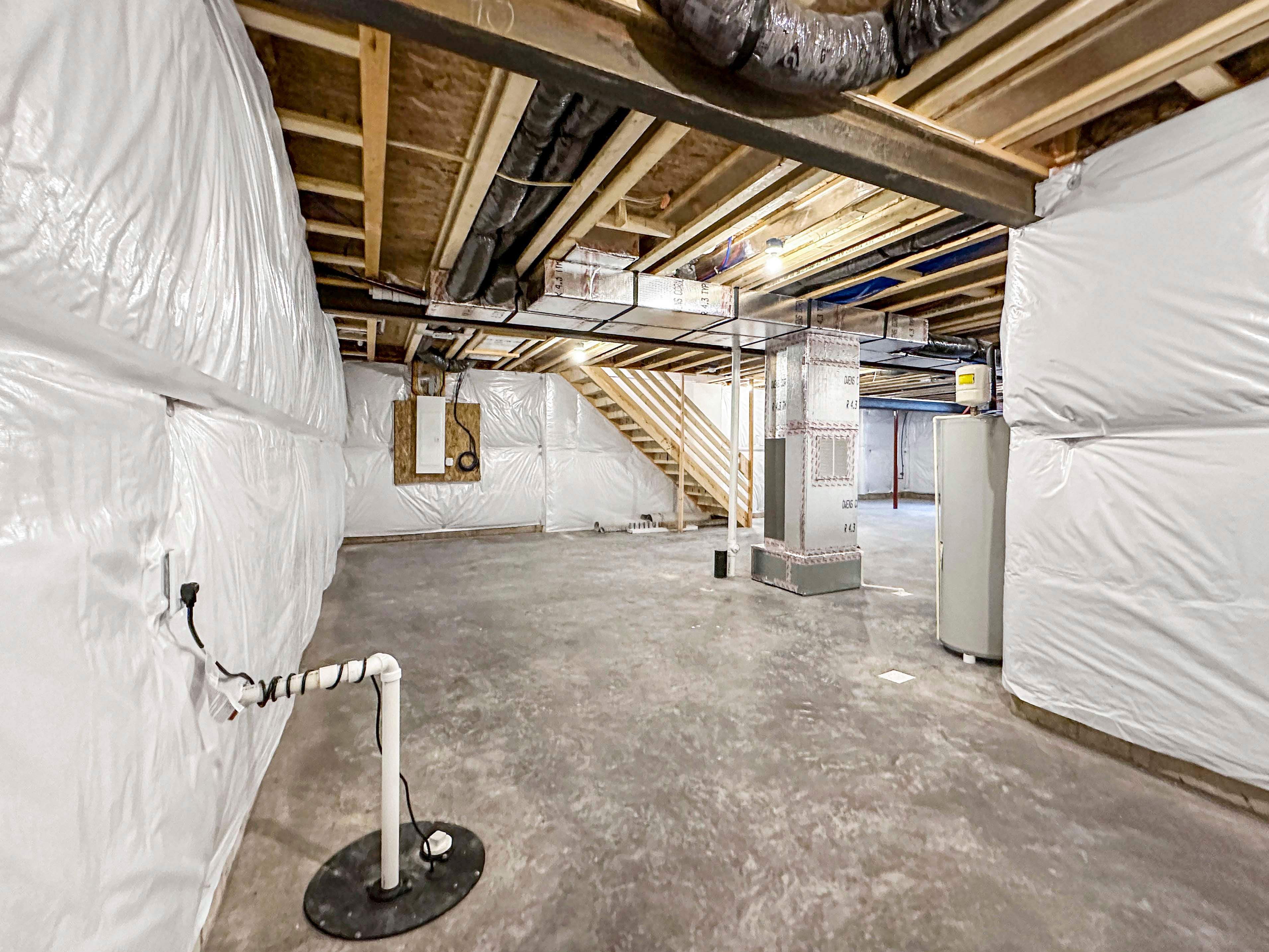 Unfurnished basement featuring concrete floors, exposed ceiling beams, and ductwork. Utility equipment and stairs visible in the back.