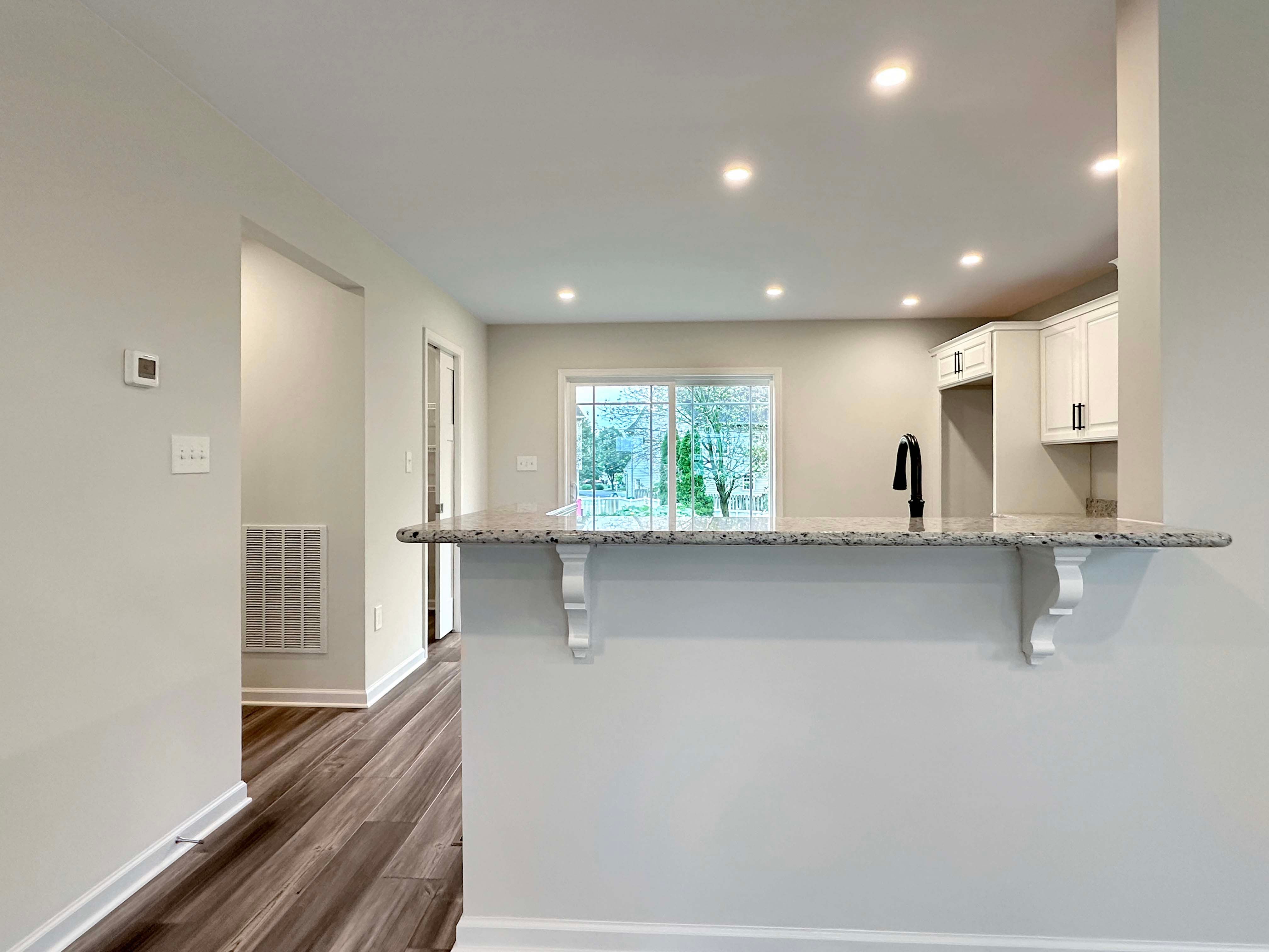 Breakfast Bar overhang with granite countertops and decorative white corbels.