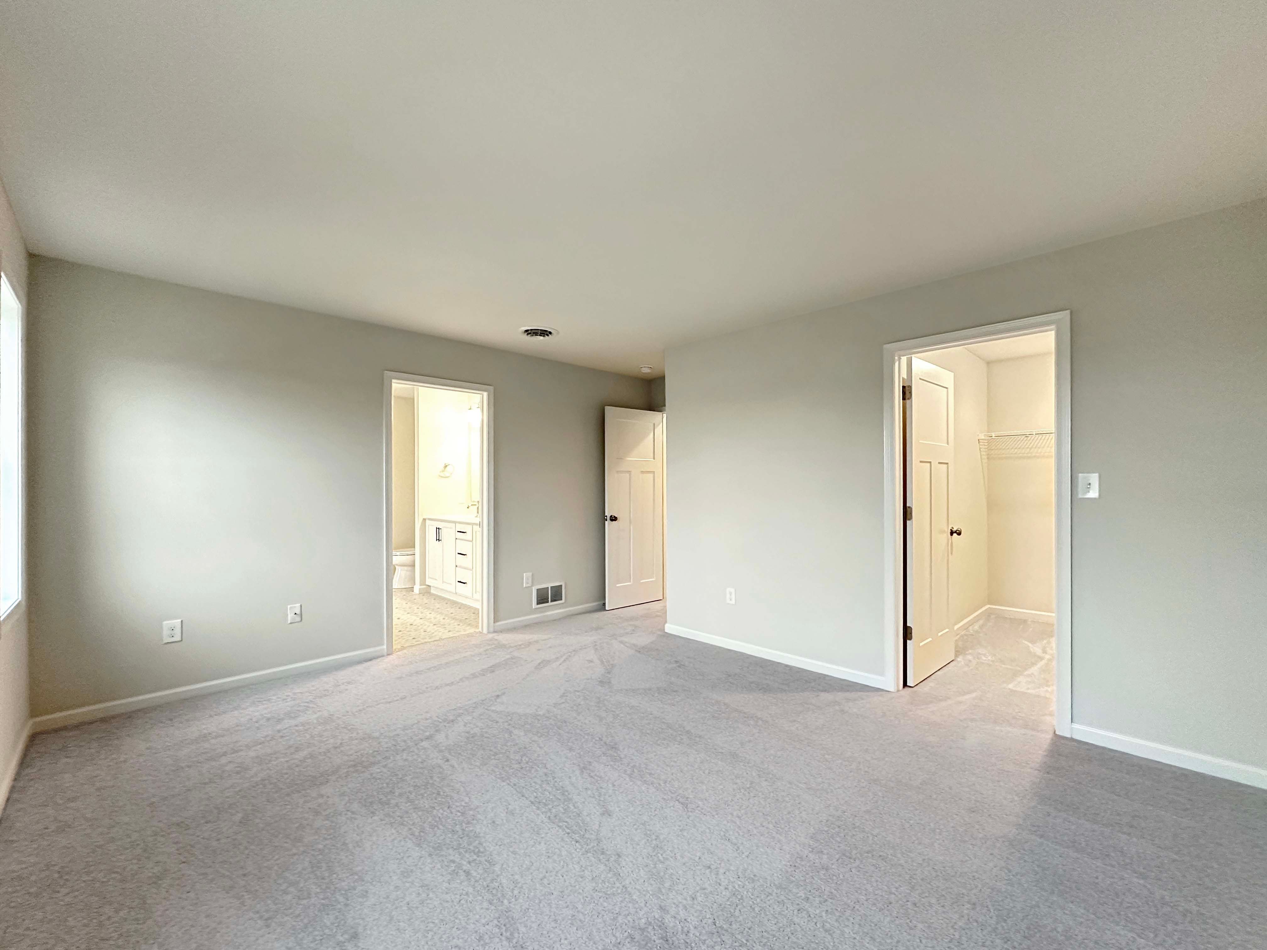 Owner's bedroom showing entry to ensuite bathroom and walk-in closet