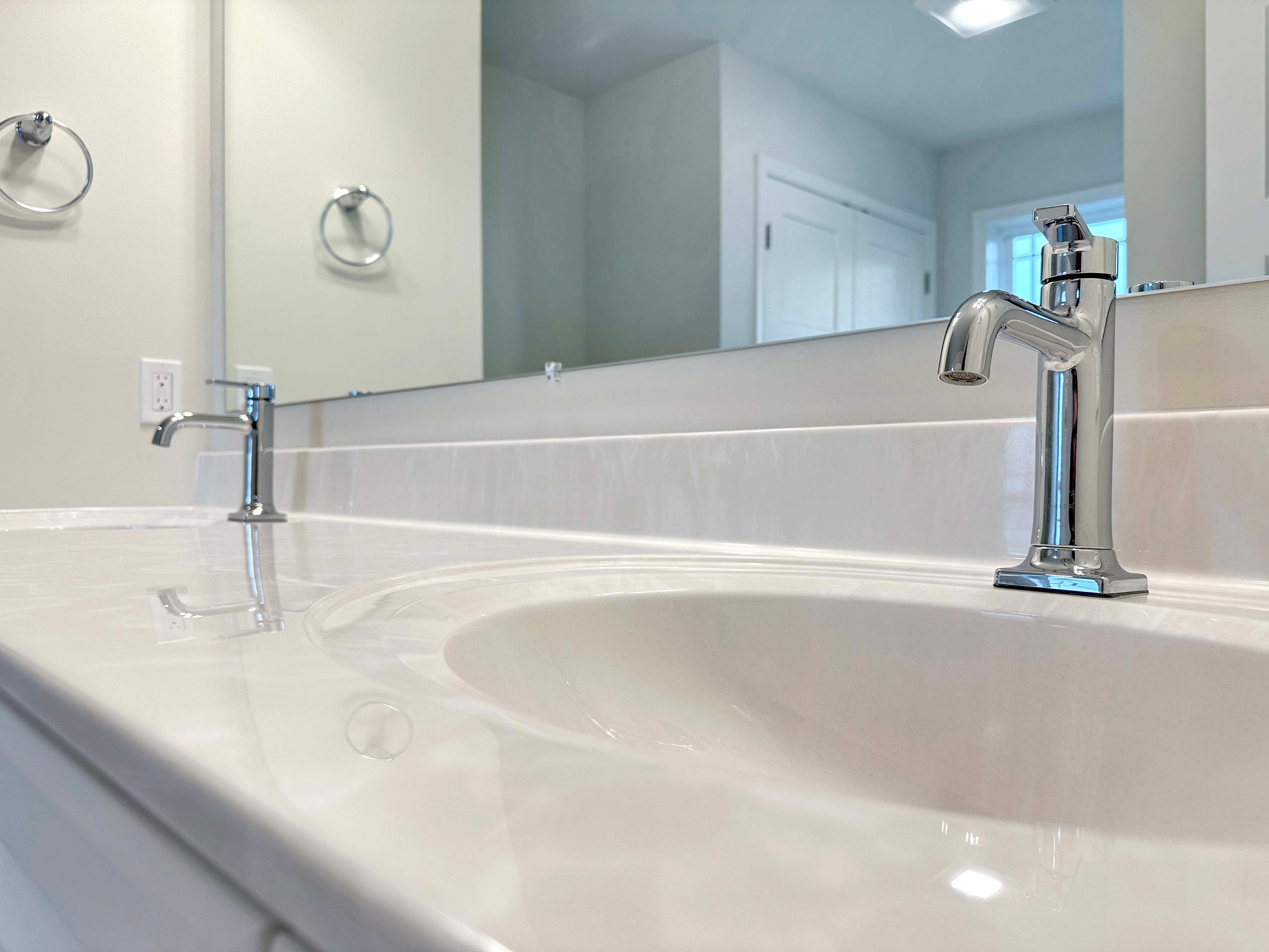 Close-up of dual sink vanity with chrome faucets in the owner's bathroom