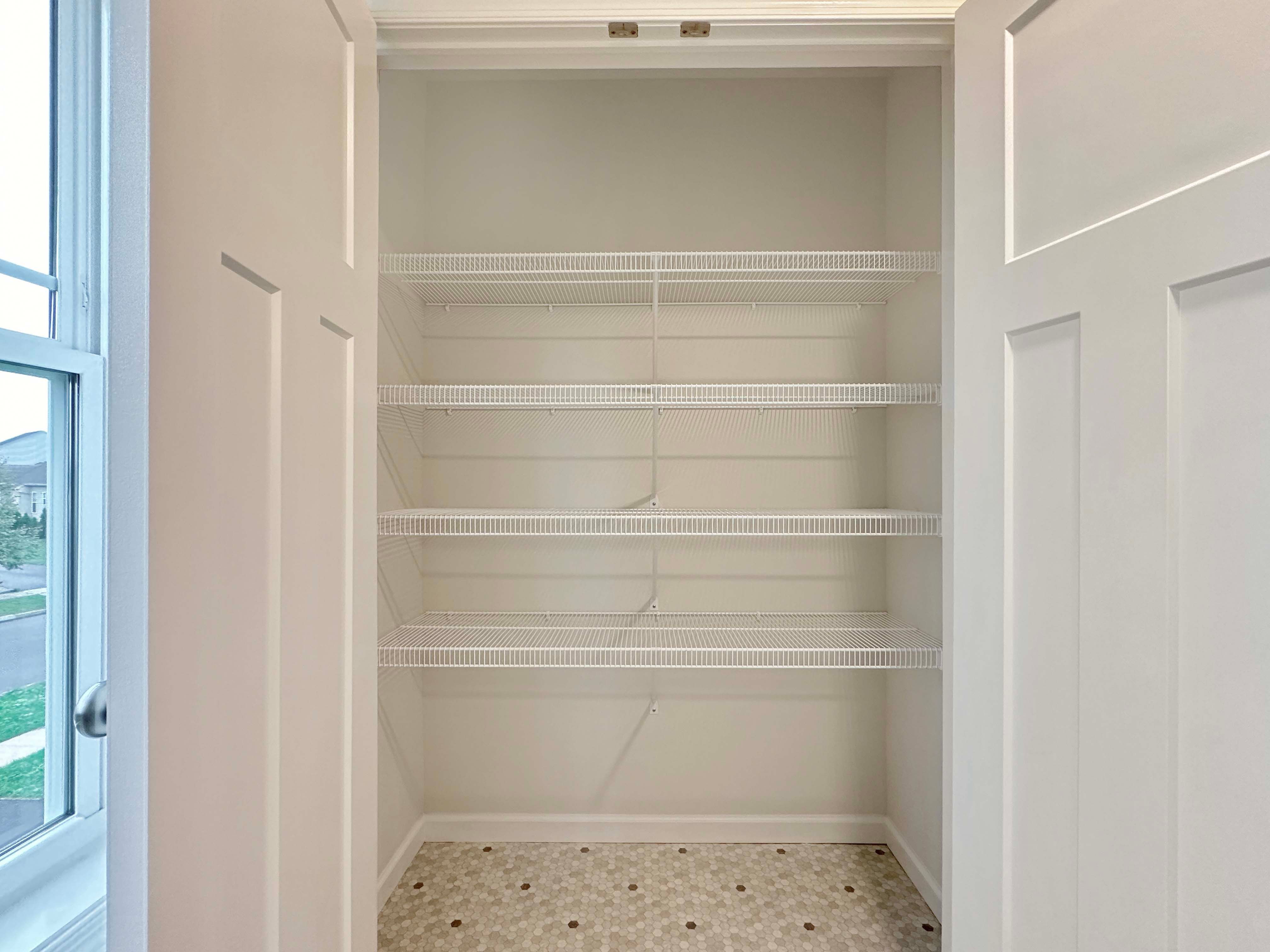 Linen closet in the owner's bathroom with wire shelving, perfect for extra towels and toiletries.