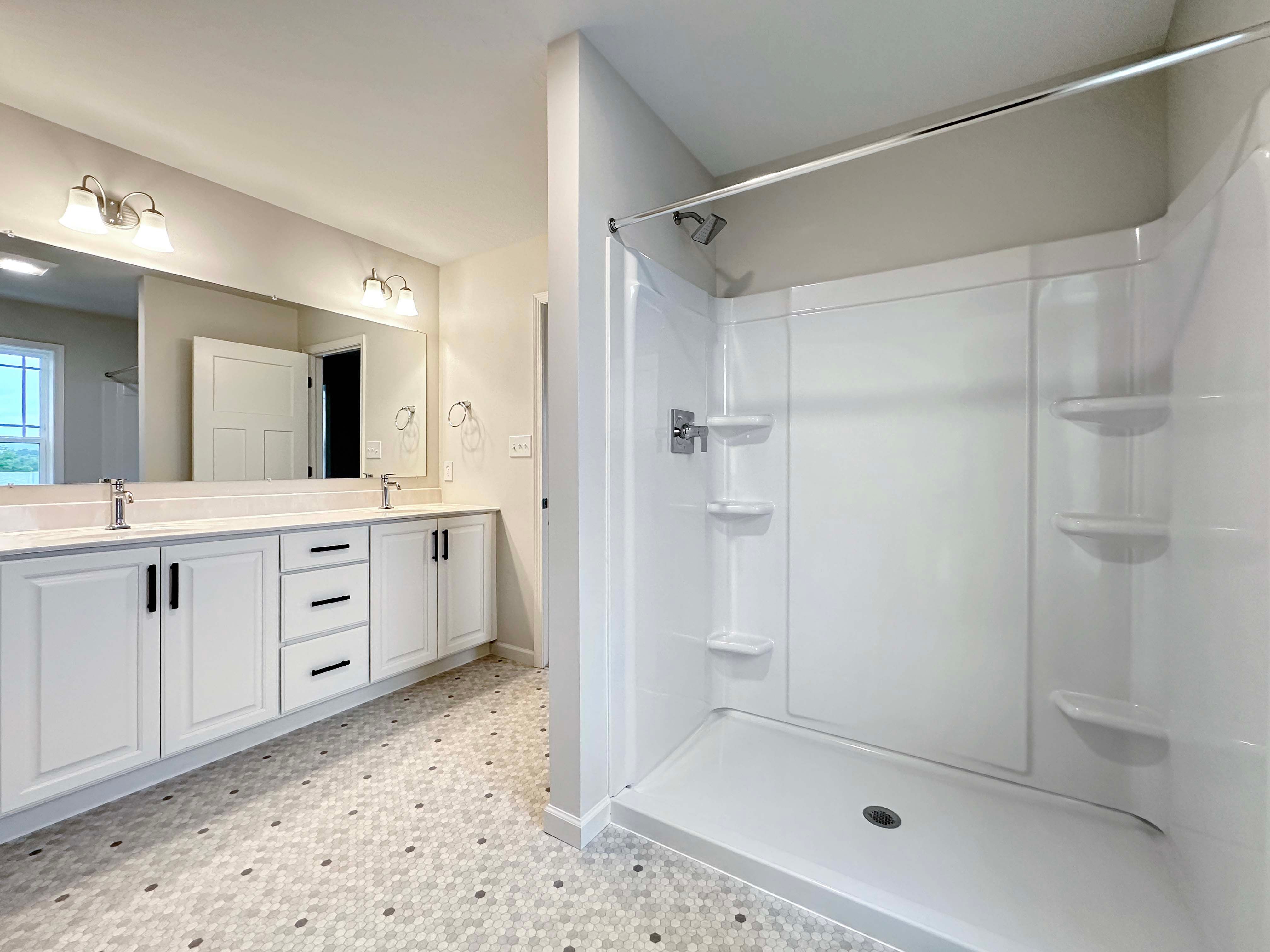 Walk-in shower with built-in shelving, located in the owner's bathroom, providing ample storage.