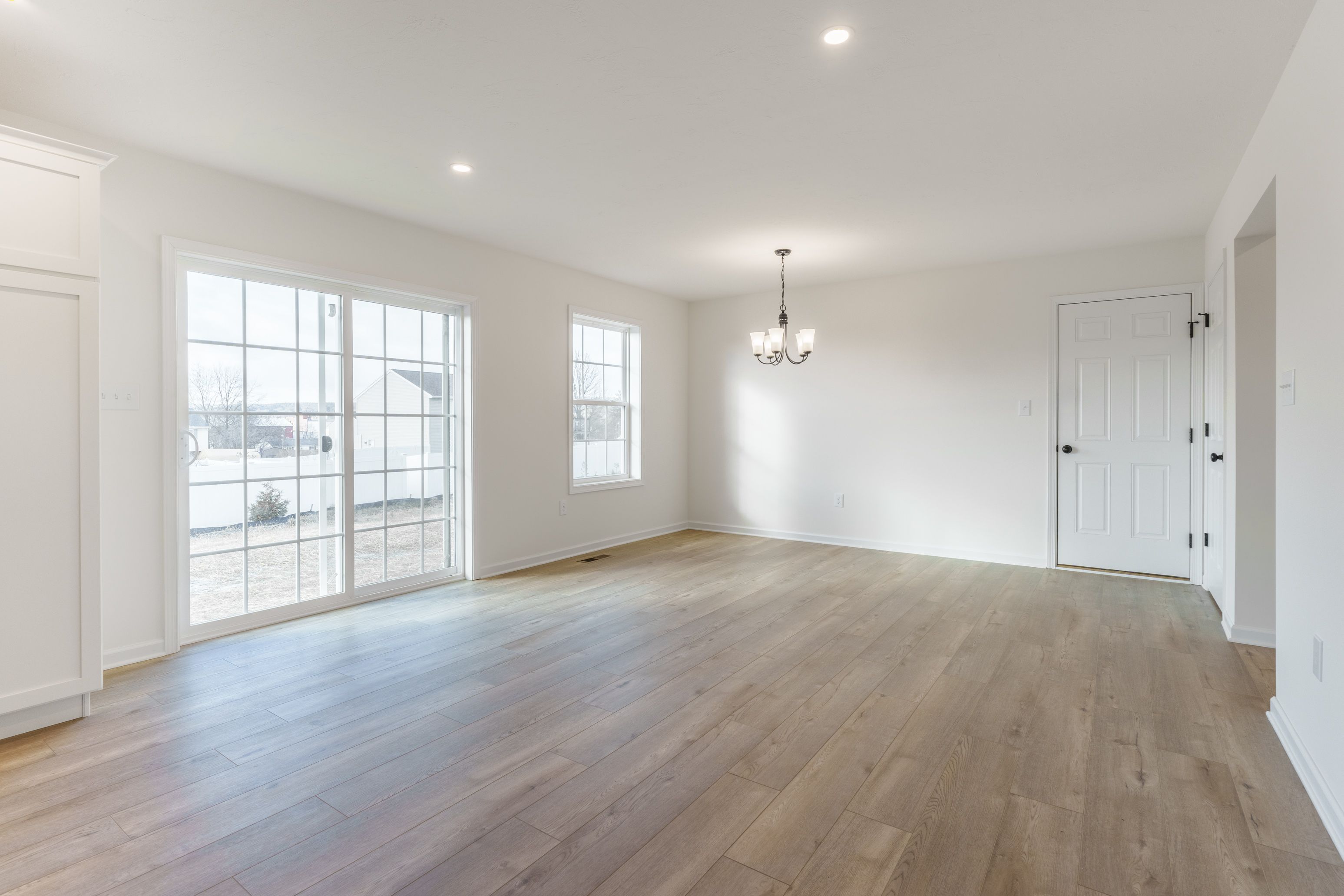 Breakfast area with large windows letting in natural light and luxury vinyl plank flooring.