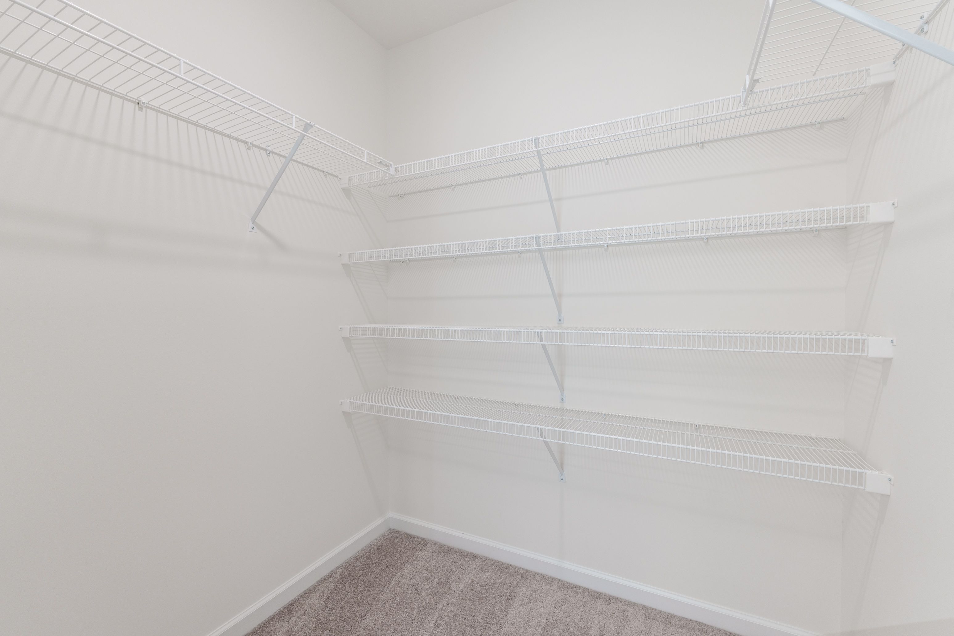 Walk-in closet in the owners bedroom with multiple shelves for organized storage.