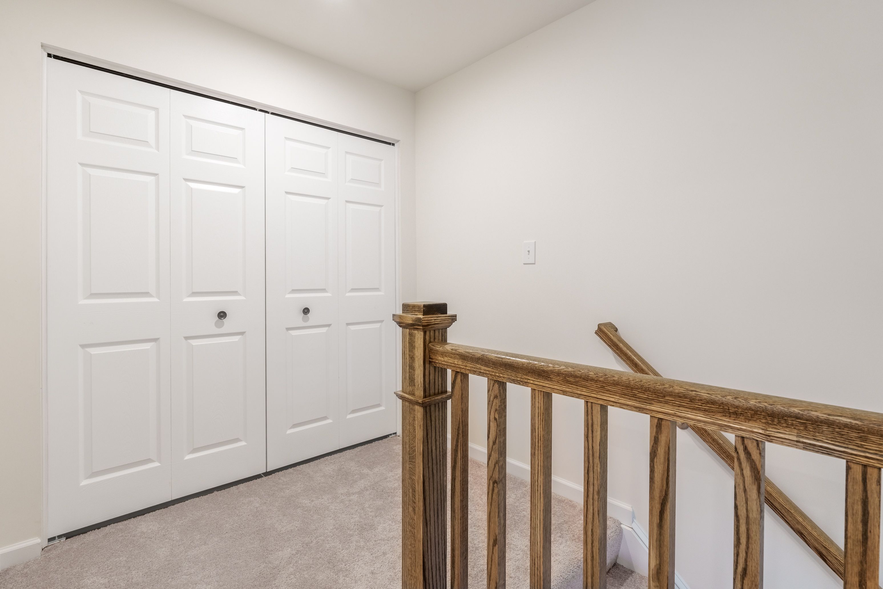 Laundry room on the second floor with wire shelving, utility hookups, and neutral wall colors.