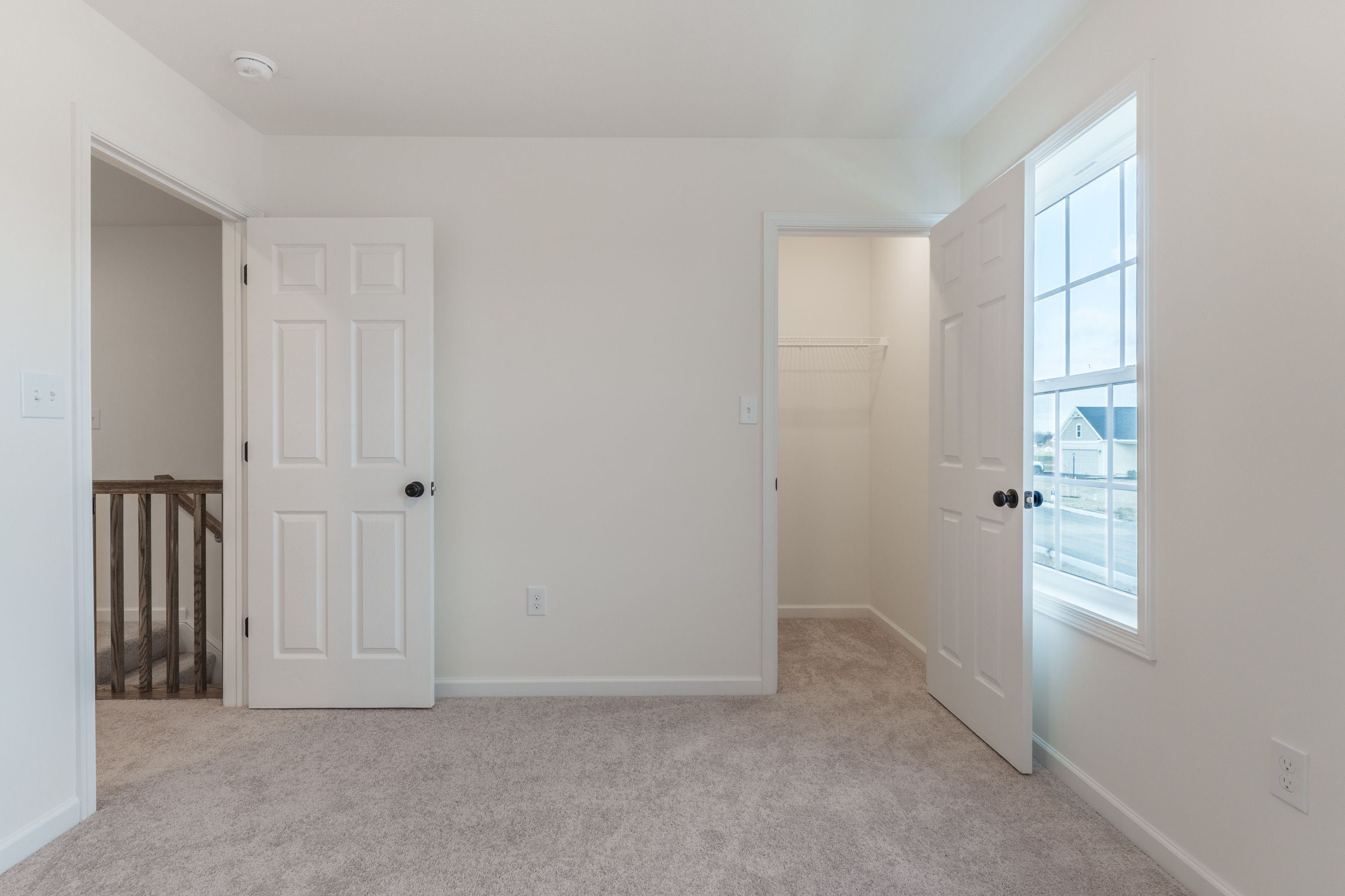 Bedroom with light carpet and natural light coming through a window. Closet to the right.